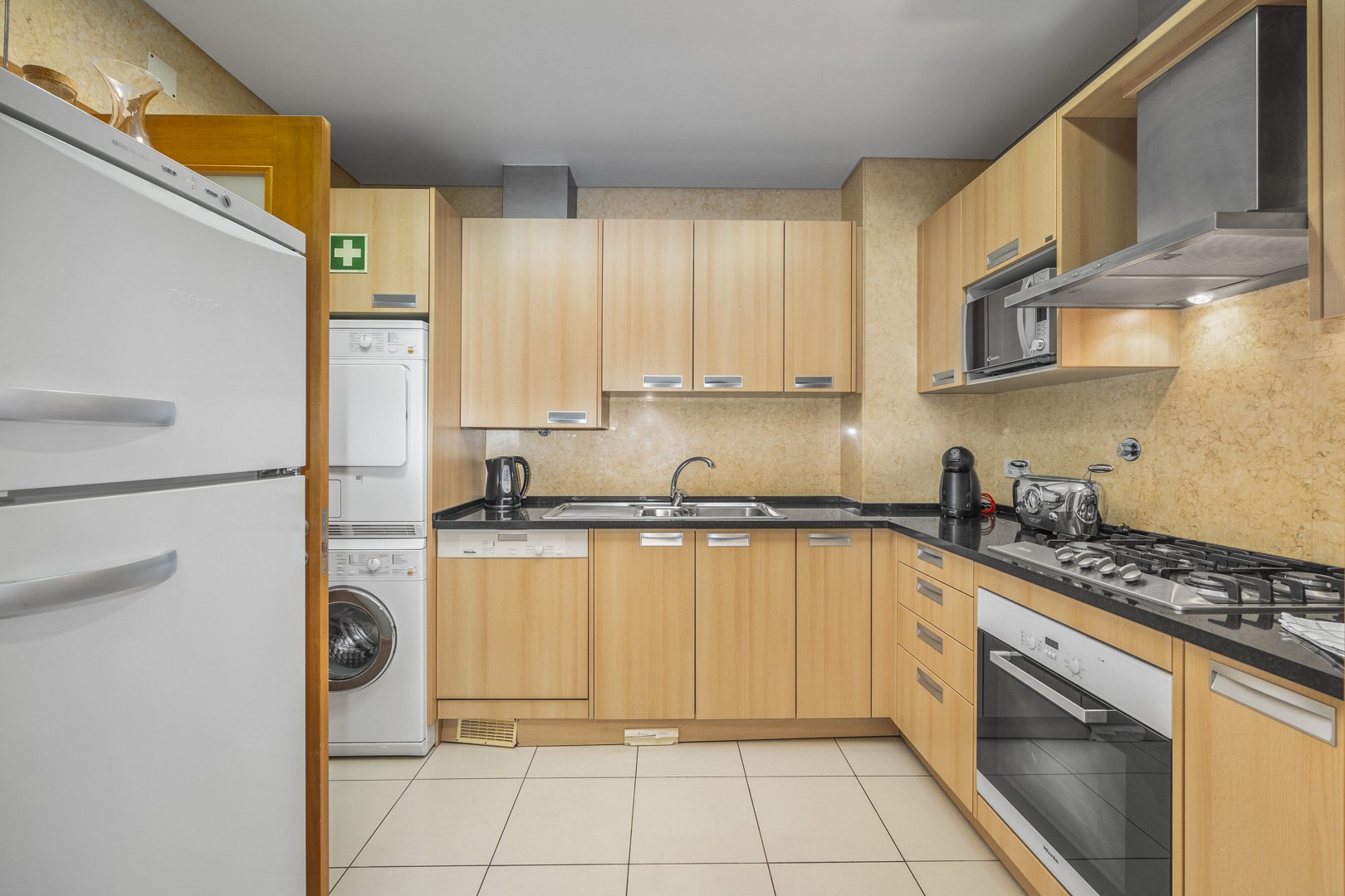 Kitchen with fridge-freezer, washing machine, and wine rack