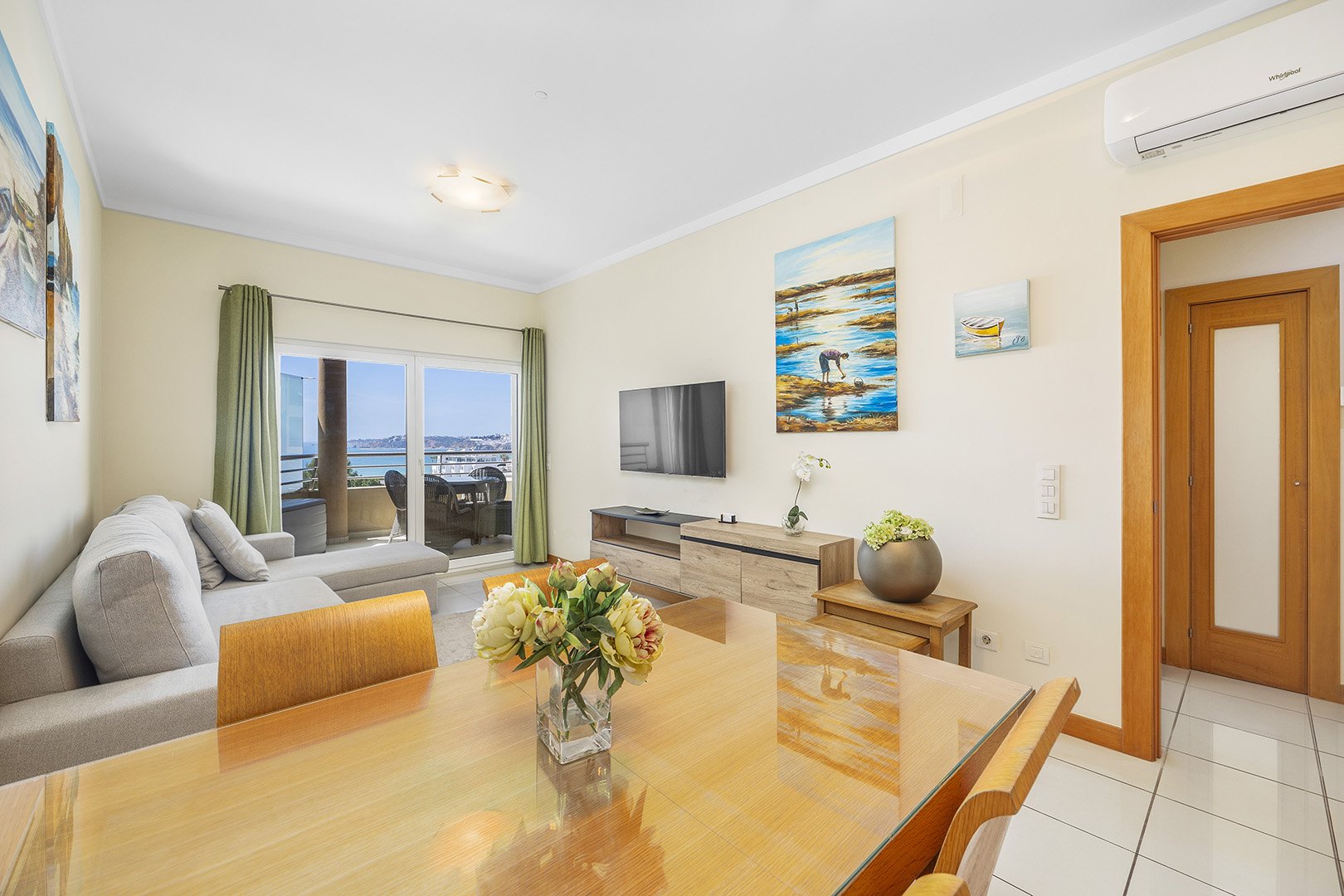 Living room with sofa, dining table, and sea view balcony