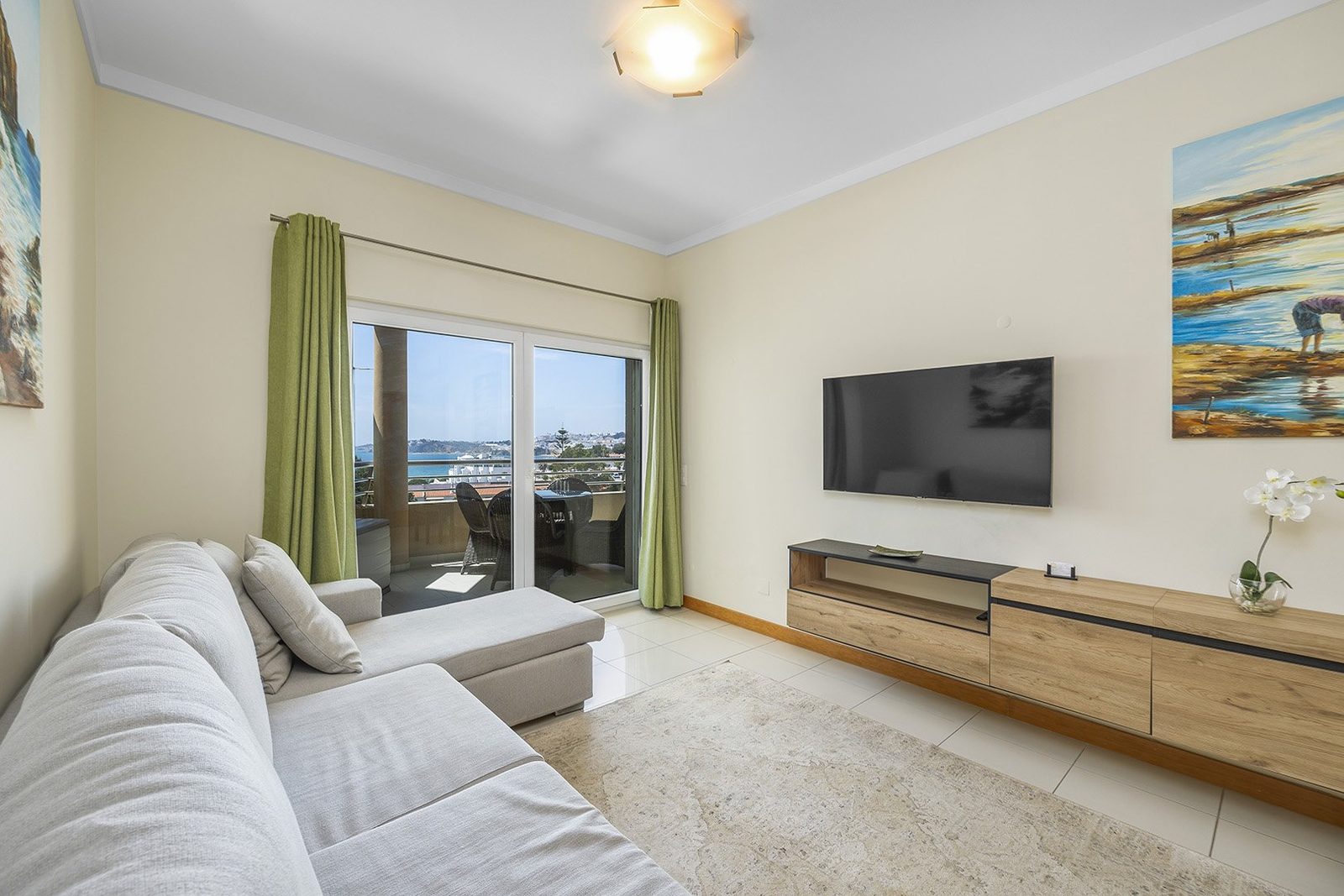 Living room with sofa, TV, and balcony access