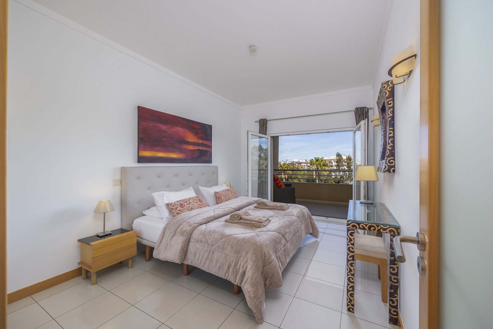 Bedroom with double bed, artwork, and balcony access