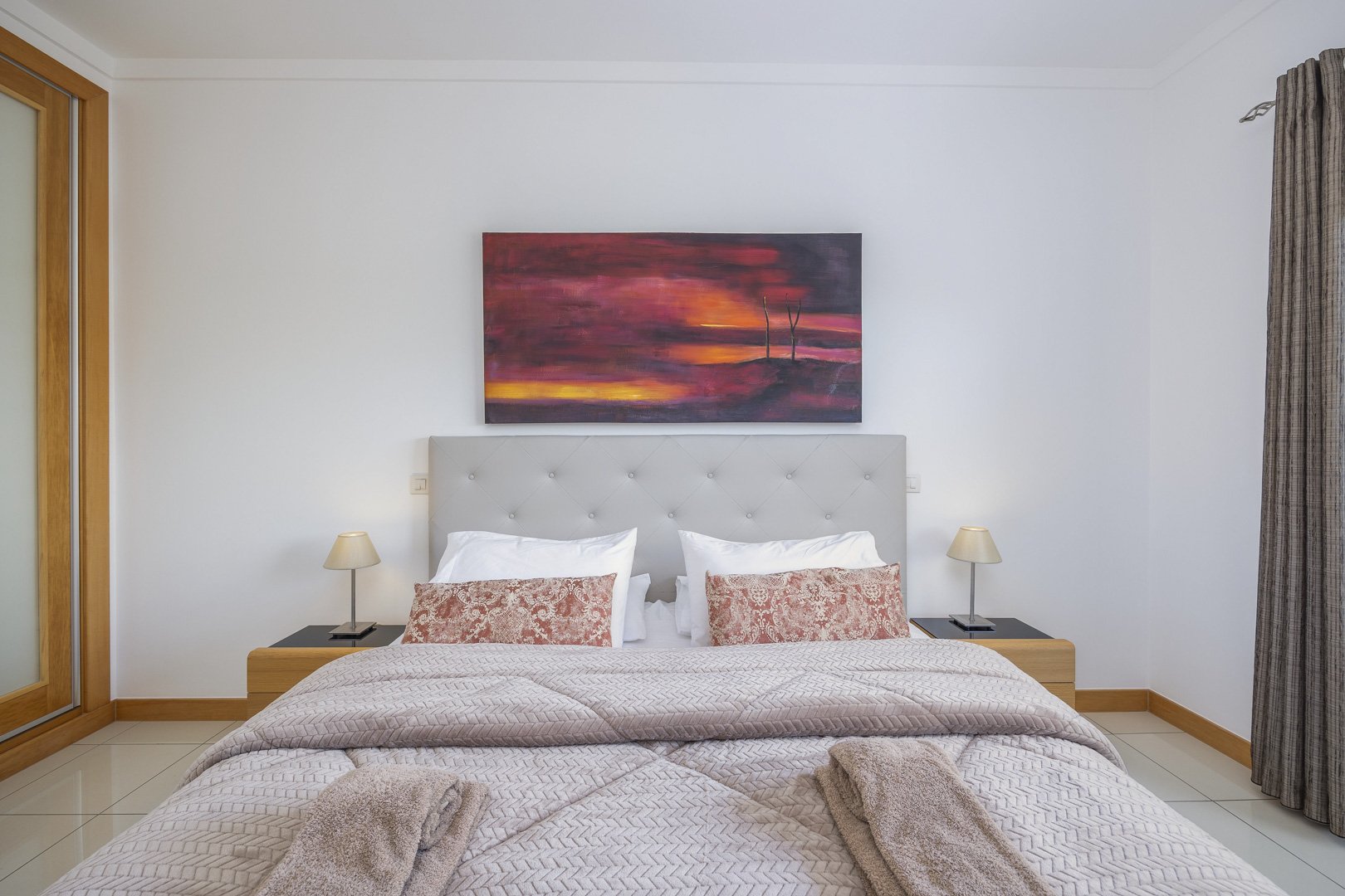 Bedroom with double bed and sunset artwork above the headboard