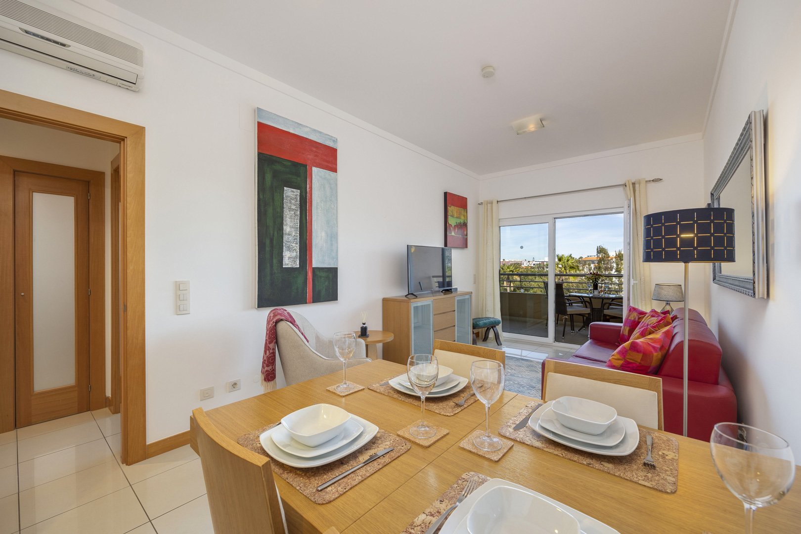 Living and dining area with dining table set and balcony access