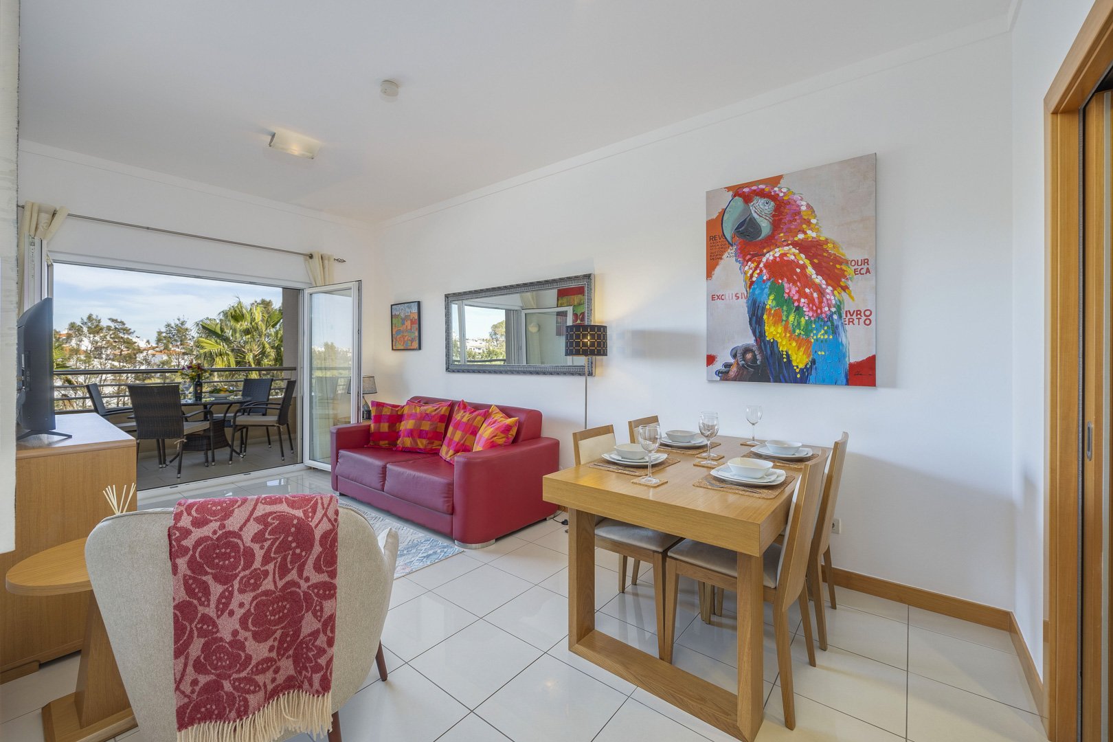Living and dining area with sofa, dining table, and mirror