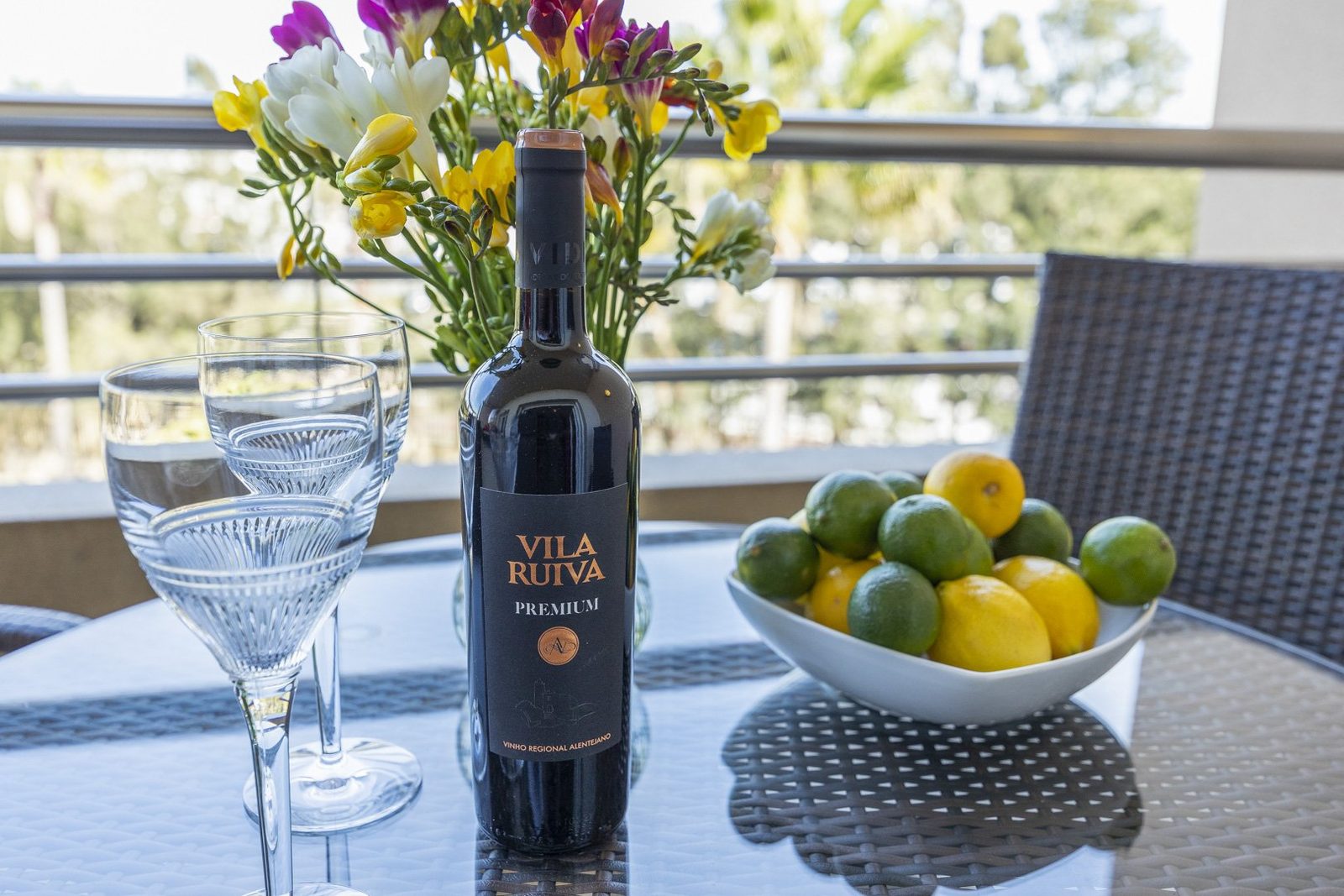 Balcony table with flowers, wine, and fresh fruit