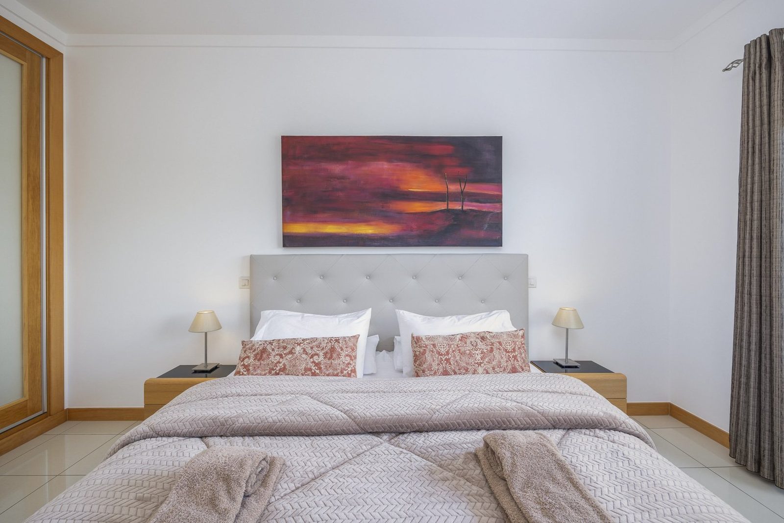Bedroom with double bed and sunset artwork above the headboard