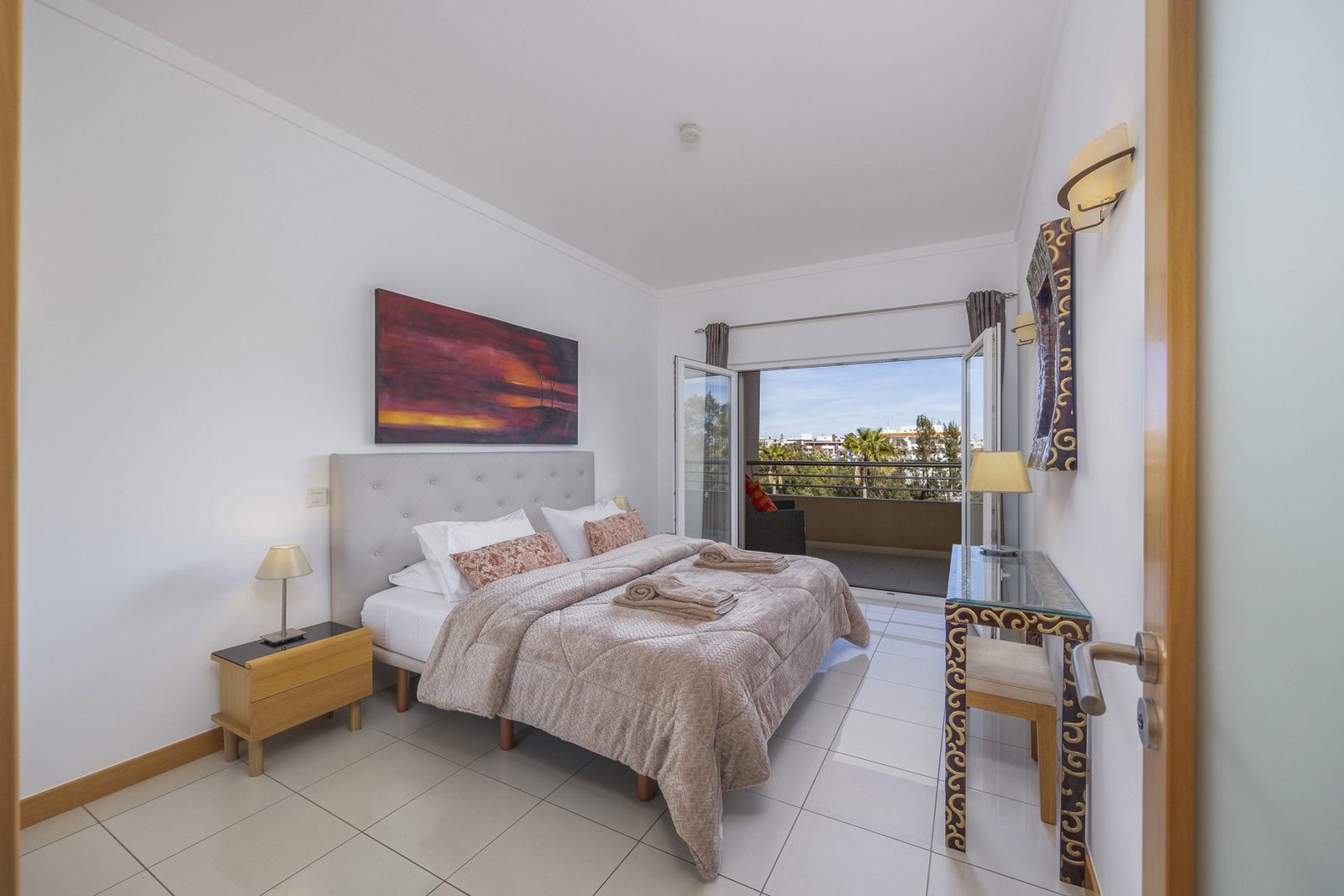 Bedroom with double bed, artwork, and balcony access