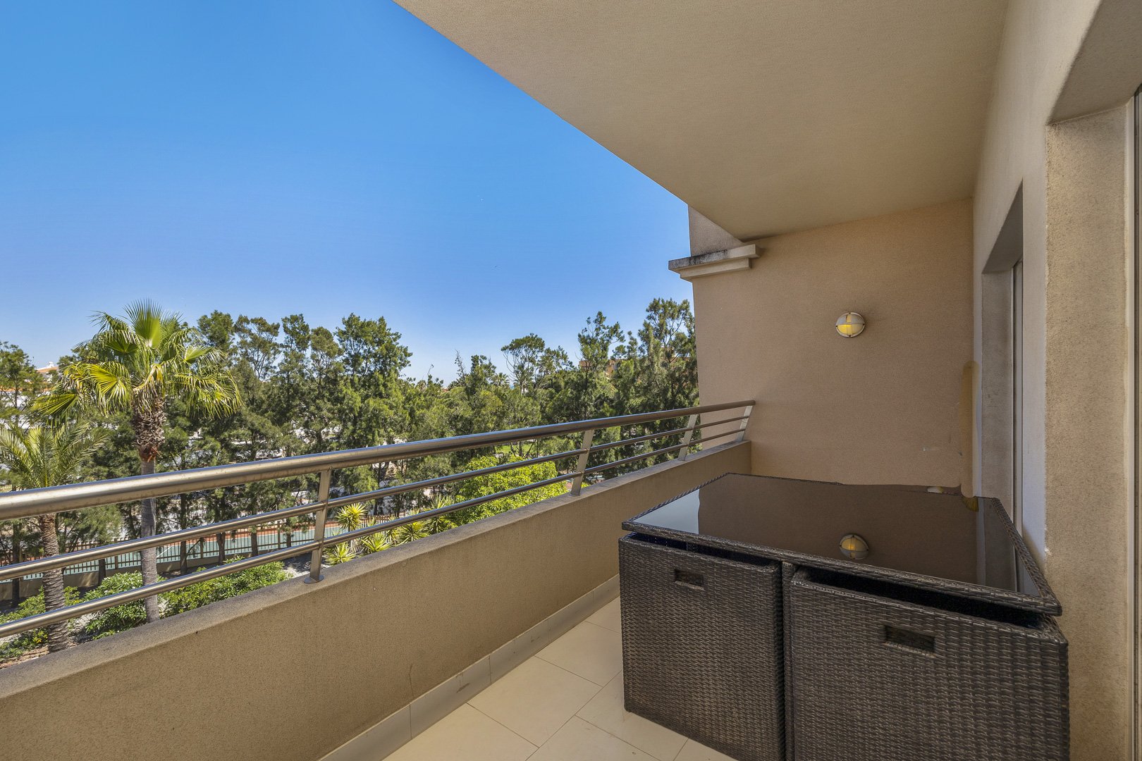 Balcony seating area with a wide treed view