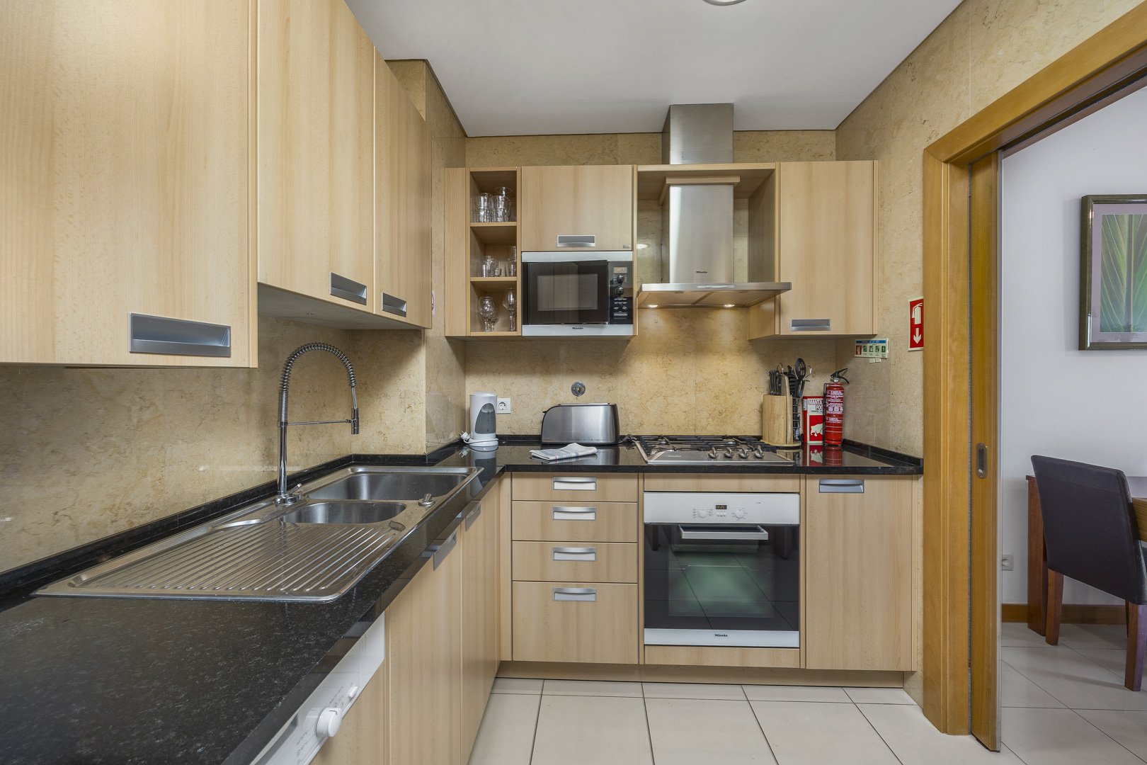 Kitchen with extractor hood, oven, and hob