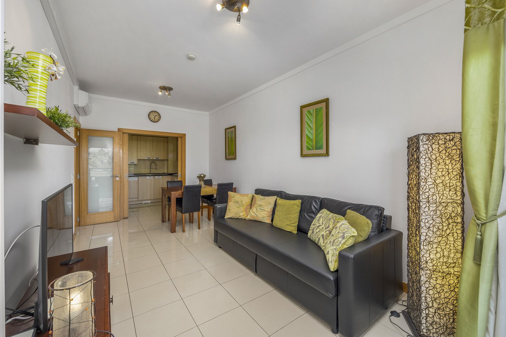 Living room with sofa and open doorway through to the kitchen and dining area