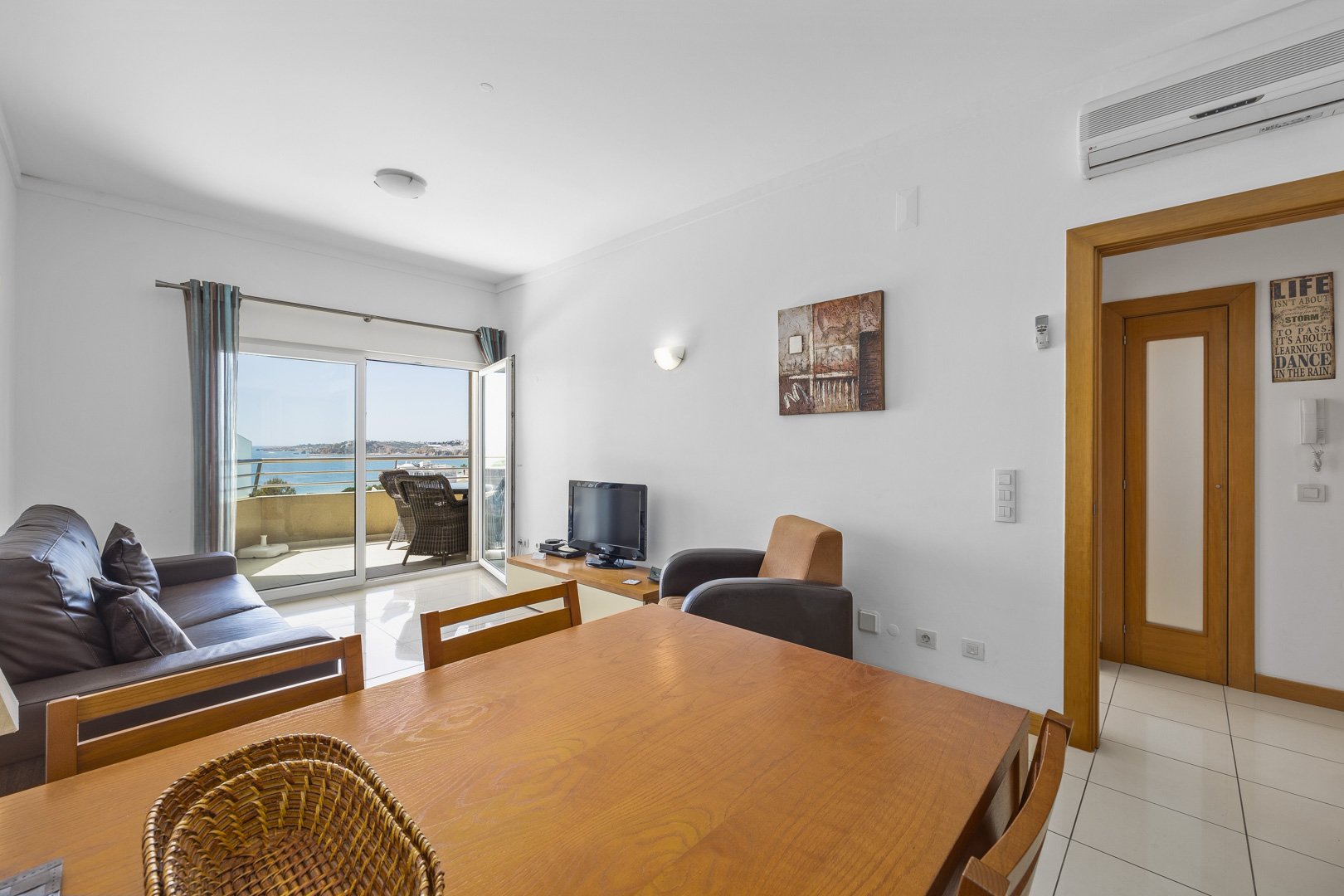 Living and dining area with dining table and sea view through the balcony doors