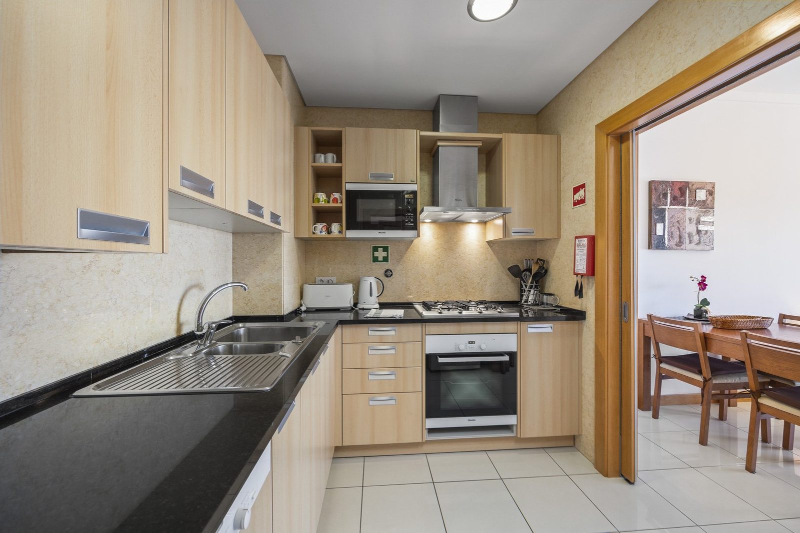 Kitchen with cabinets, extractor hood, and dining area view