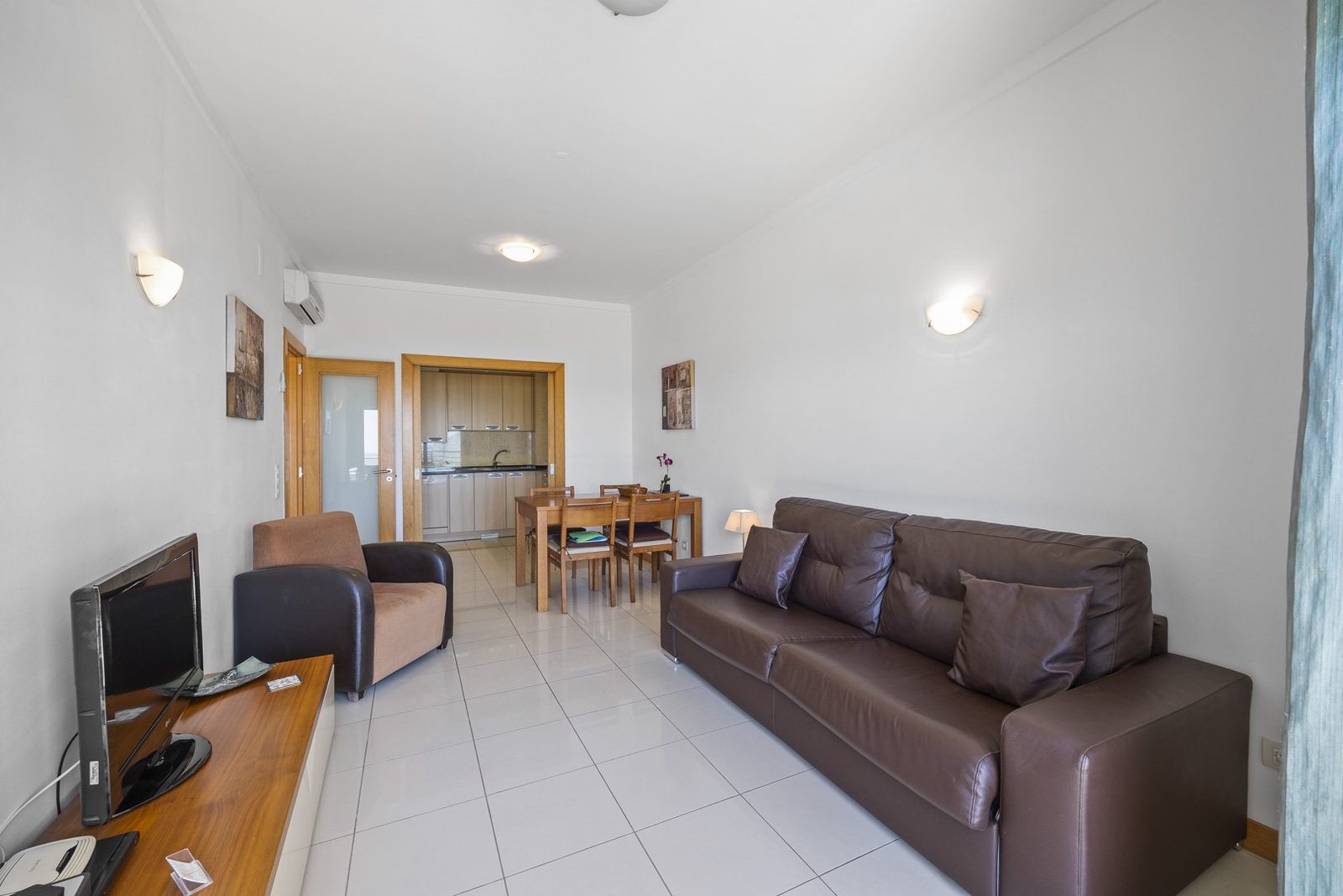 Living room with TV, armchair, and sofa