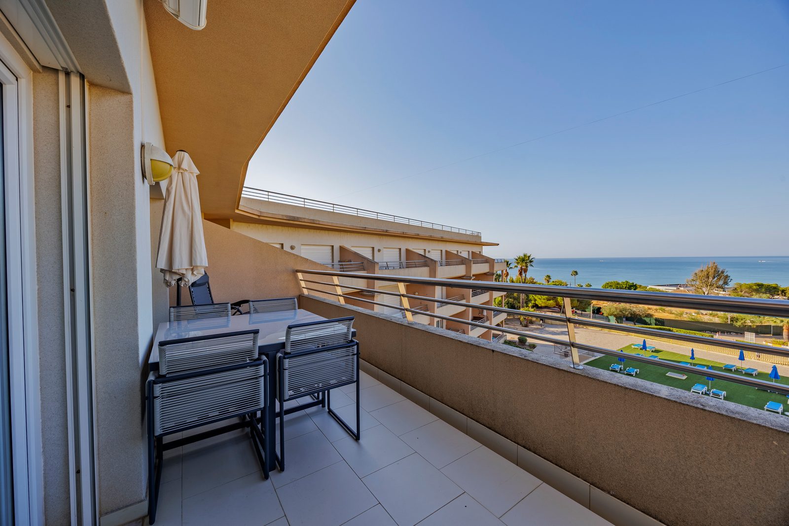 Balcony dining table overlooking the pool gardens and the sea