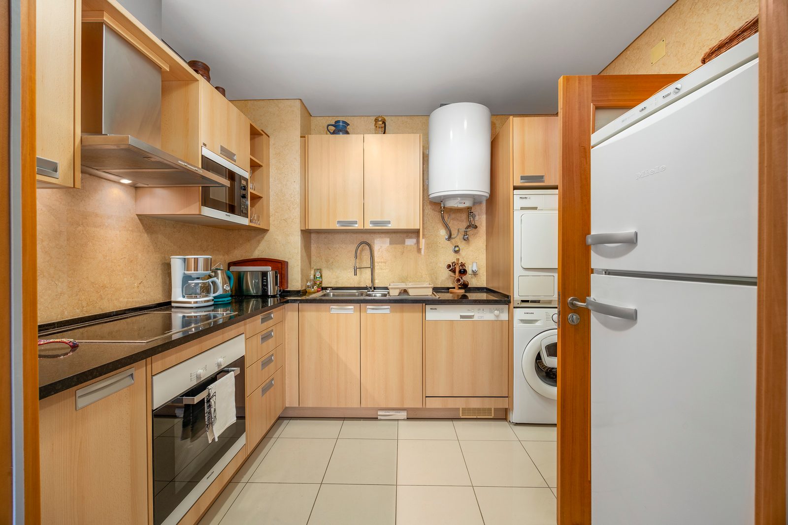 Kitchen with fridge-freezer, washing machine, and tumble dryer