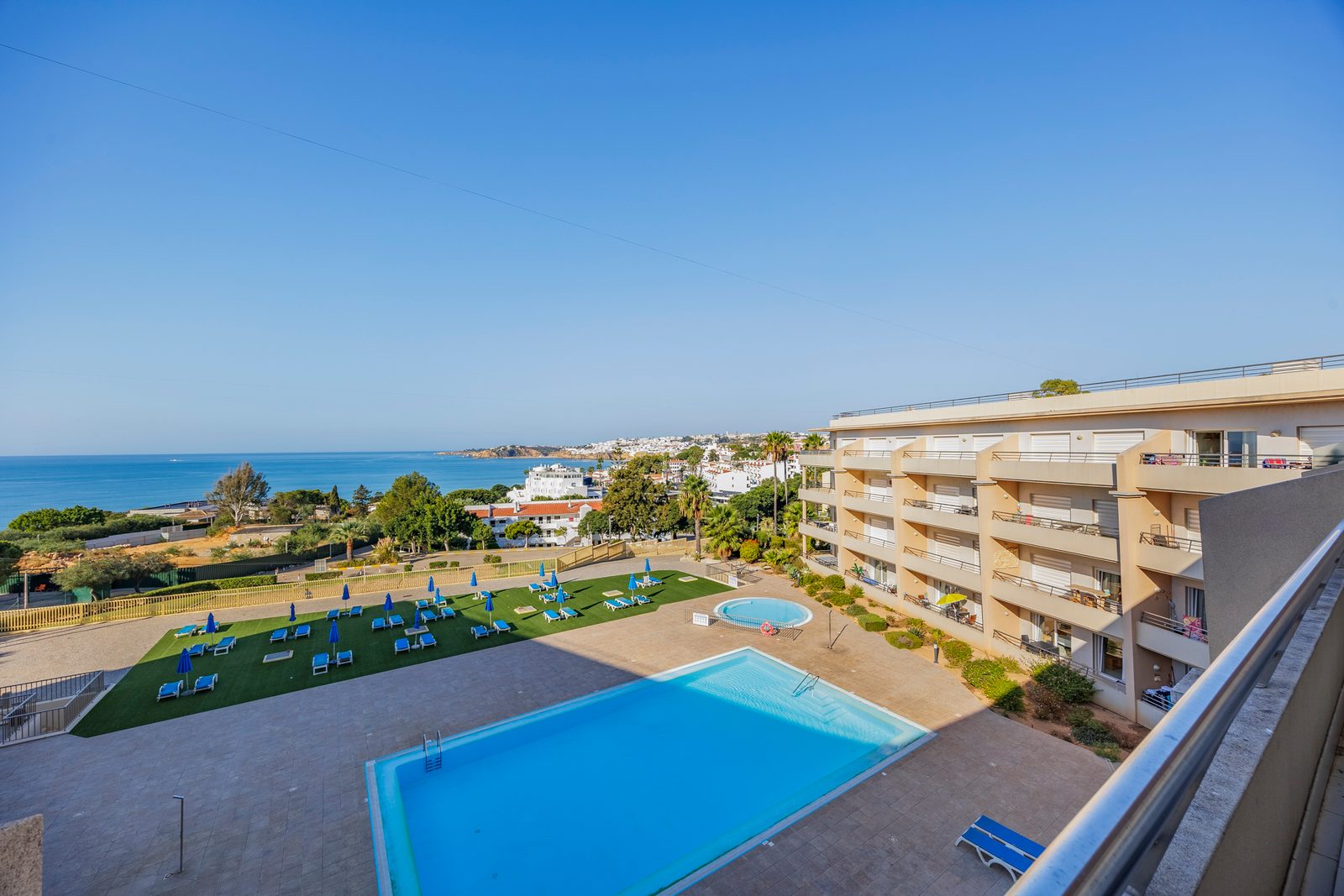 View down to the pool, gardens, and sea from the balcony