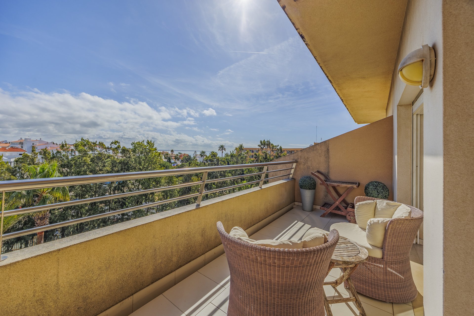 Balcony with rattan chairs and elevated coastal view