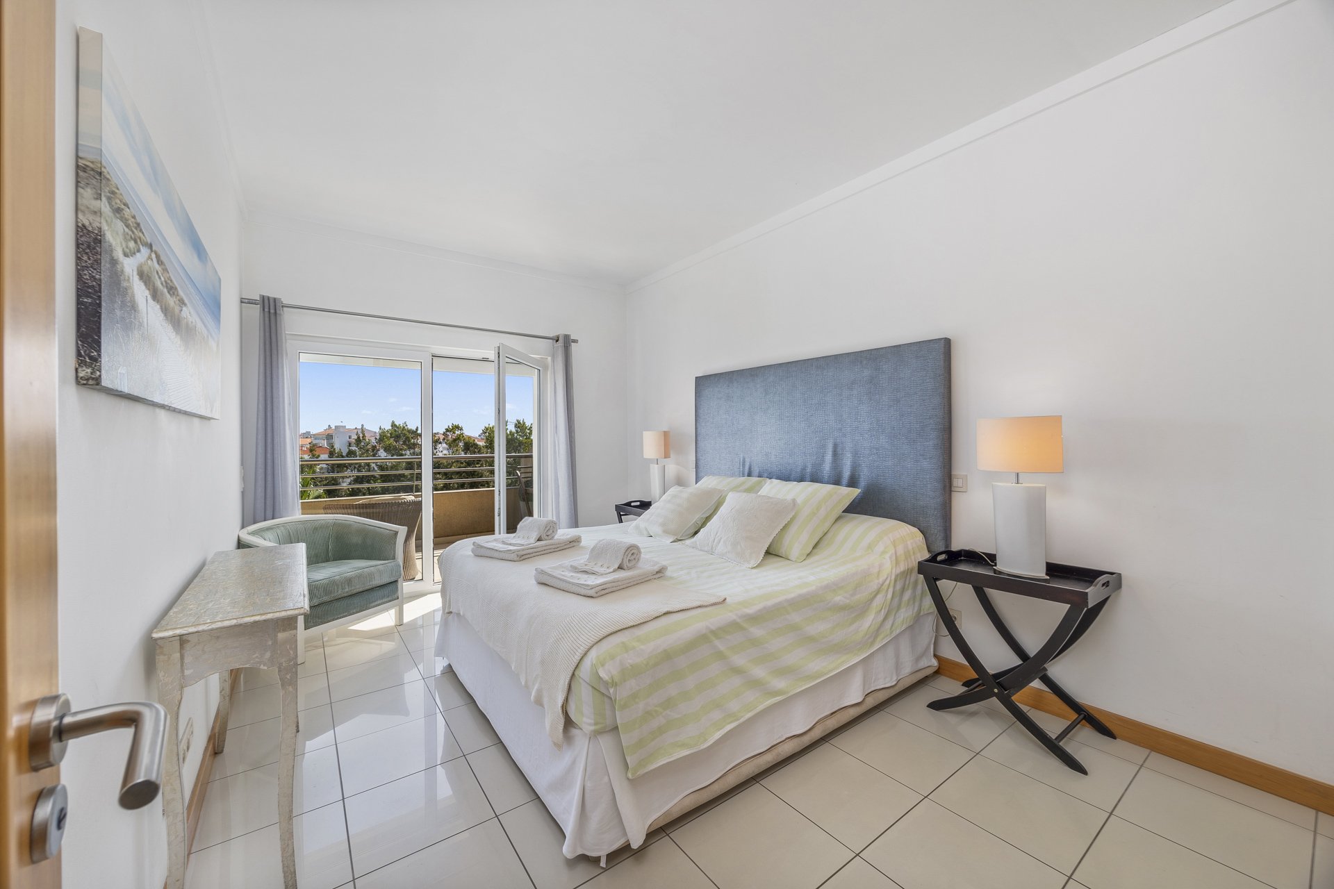 Bedroom with blue upholstered headboard and balcony access
