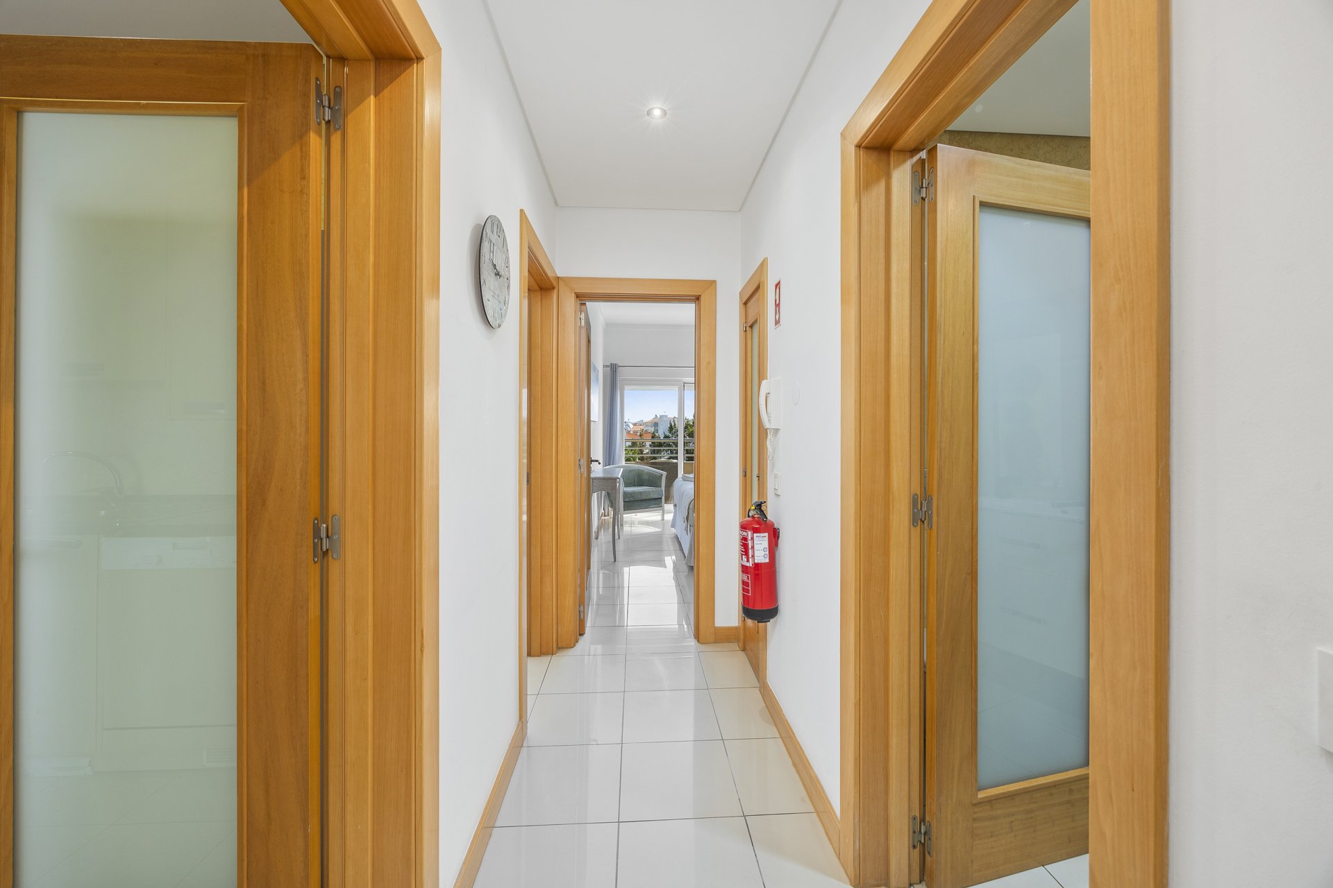 Hallway with wall clock and doors leading to the bedrooms