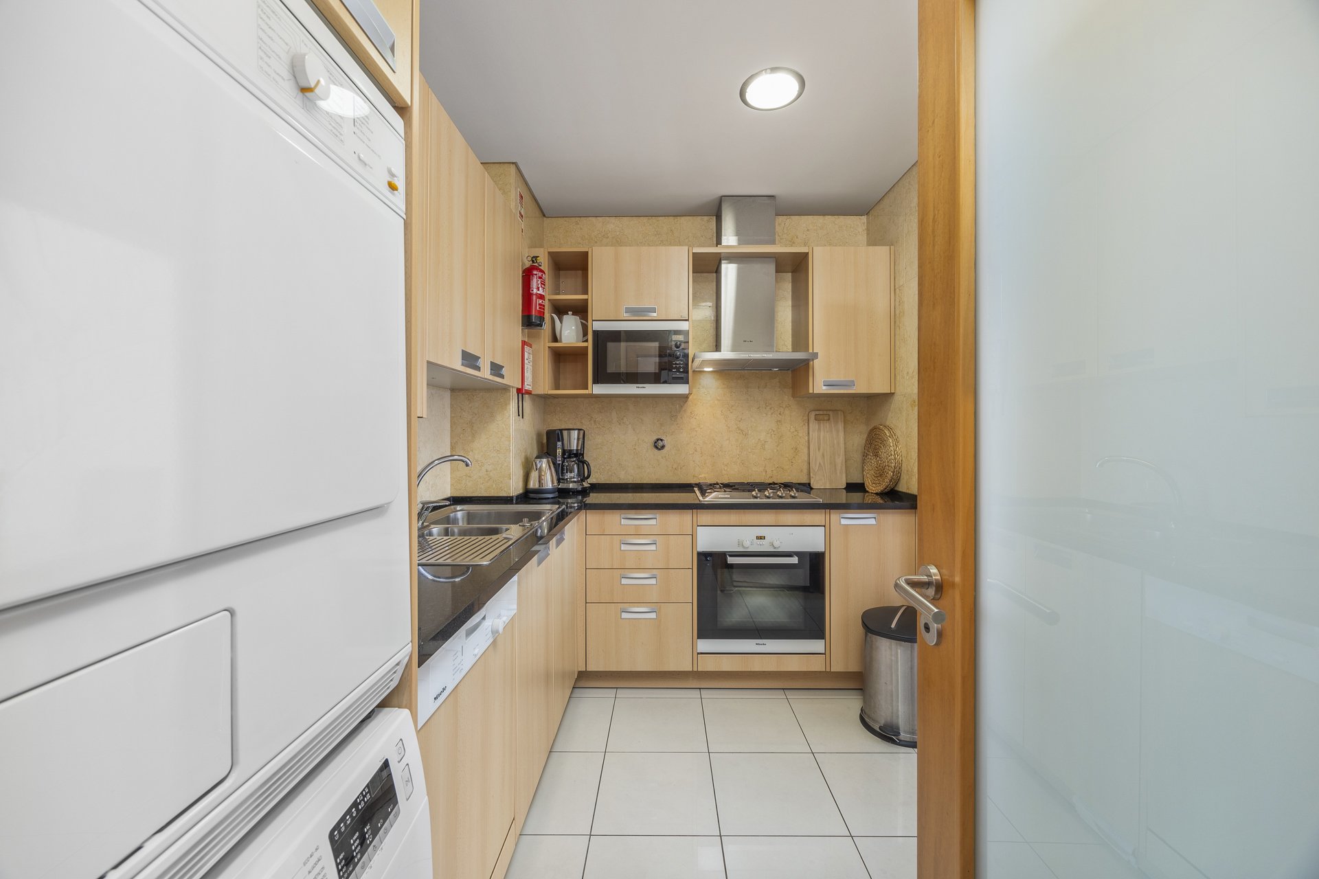 Kitchen with stacked washer-dryer and cooking area