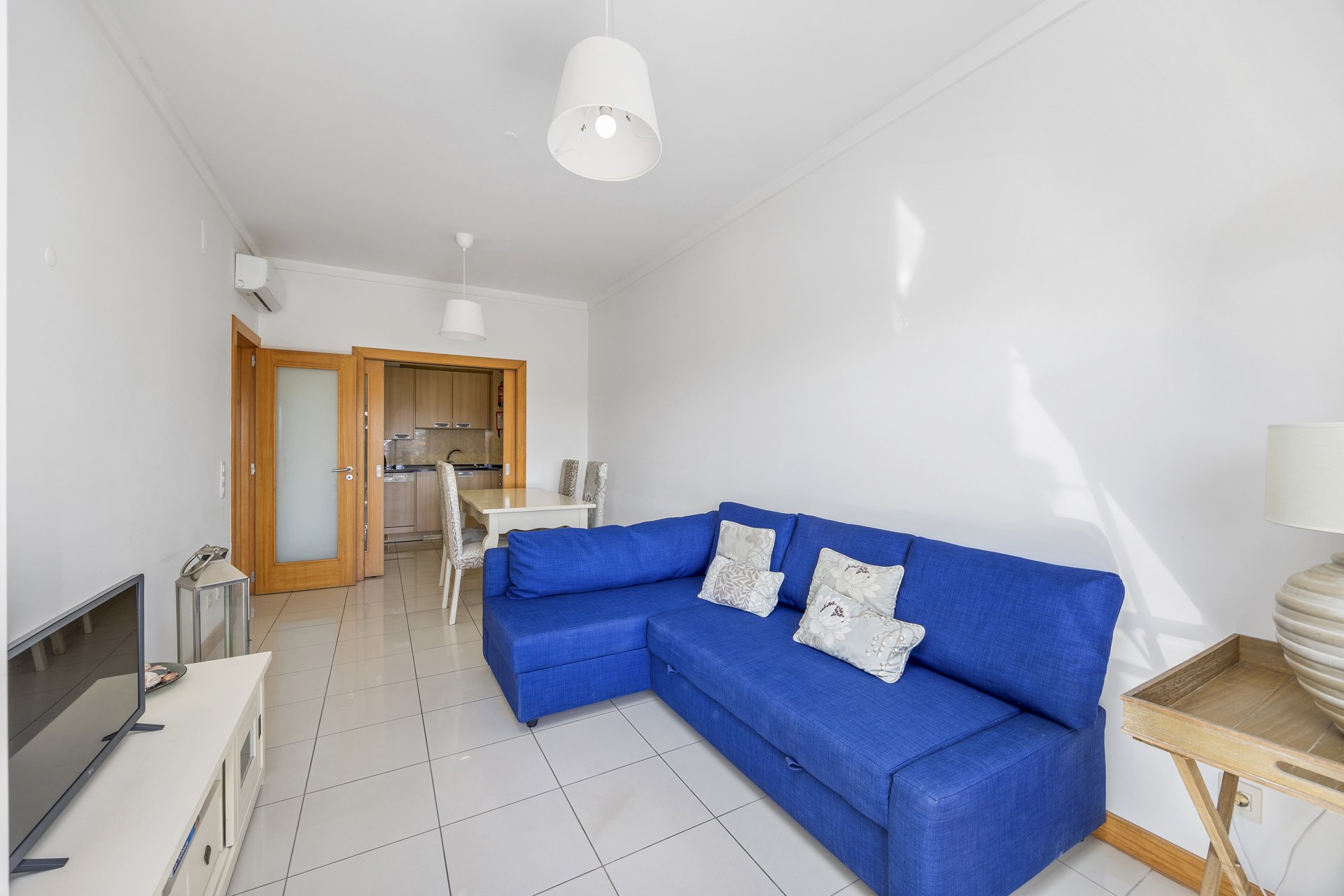 Living room with sofa and open view through to the kitchen and dining area