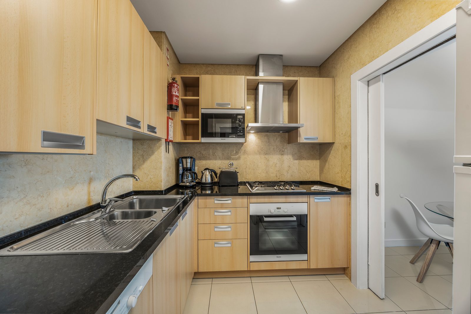 Kitchen with double sink, oven, microwave, and dishwasher