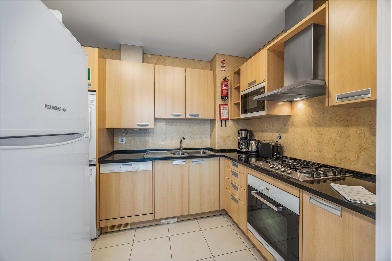 Kitchen with gas hob, oven, extractor hood, and fridge-freezer