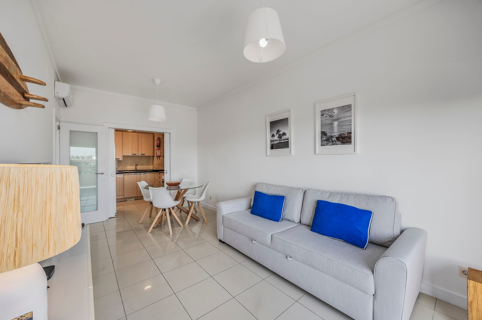 Living and dining area with sofa, dining table, and a view through to the kitchen