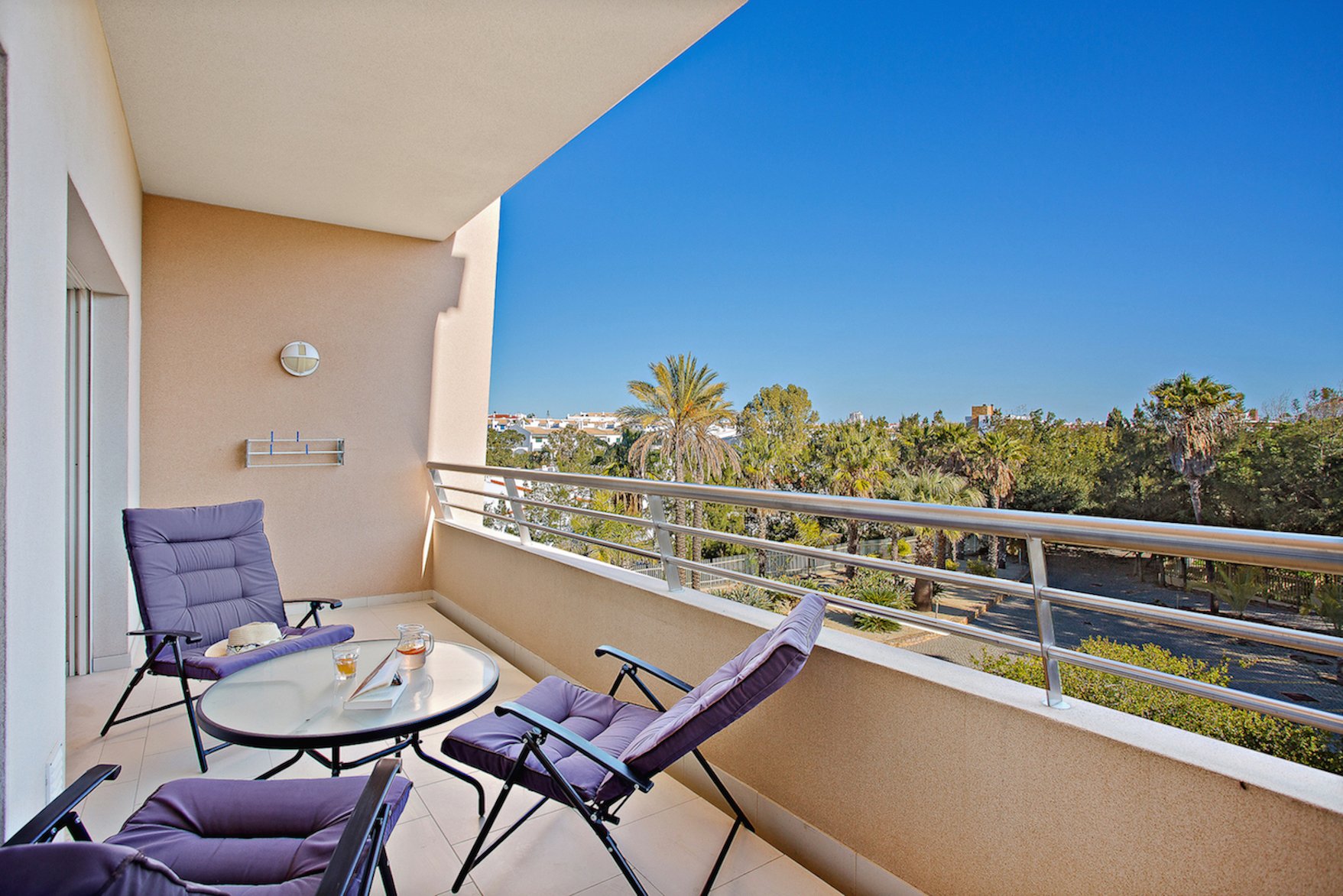 Balcony with lounge chairs, table, and garden view