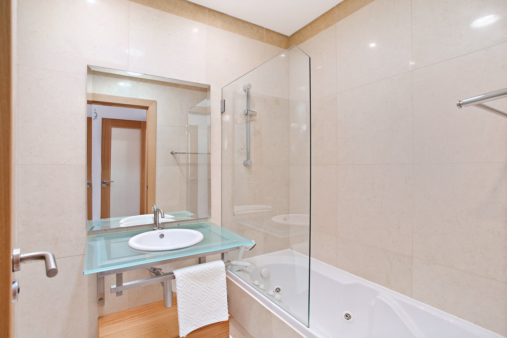 Bathroom with bathtub, glass shower screen, and vanity sink