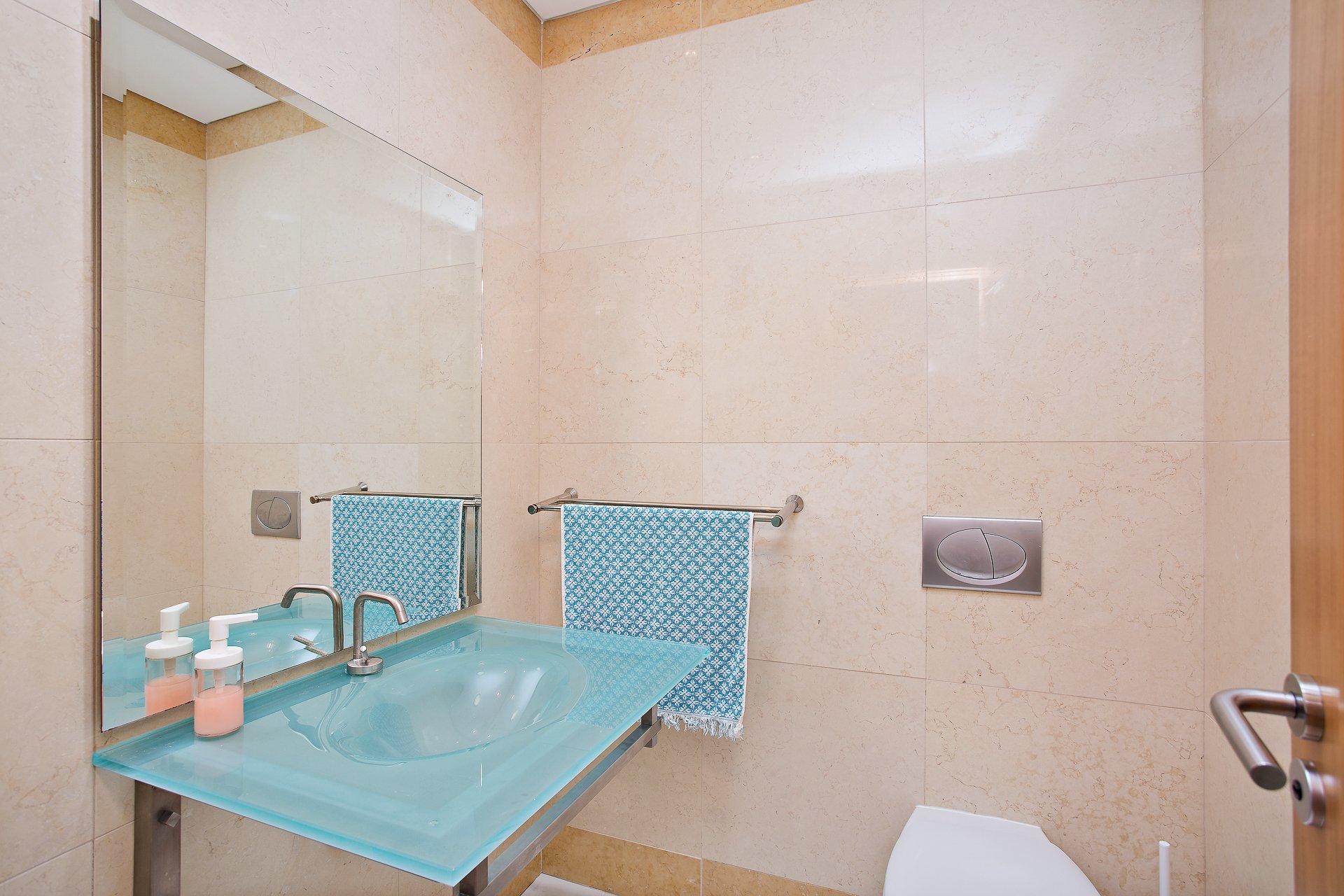 Washroom with pastel blue vanity sink and toilet
