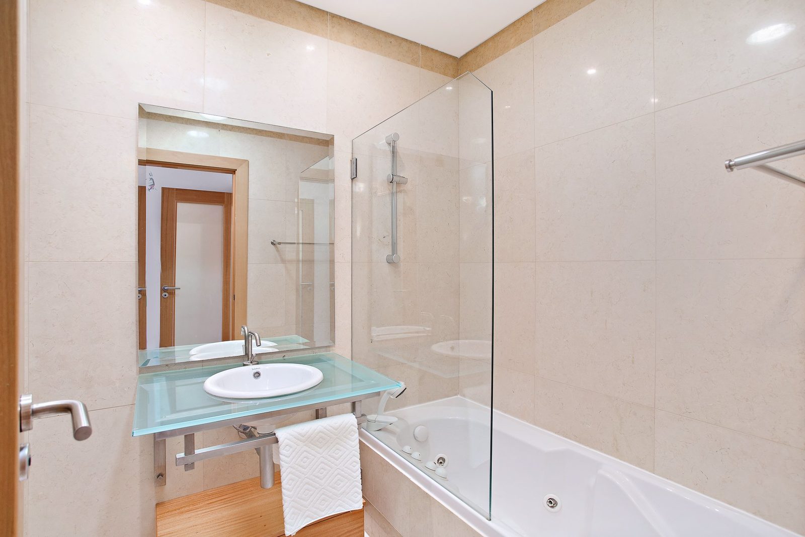 Bathroom with bathtub, glass shower screen, and vanity sink