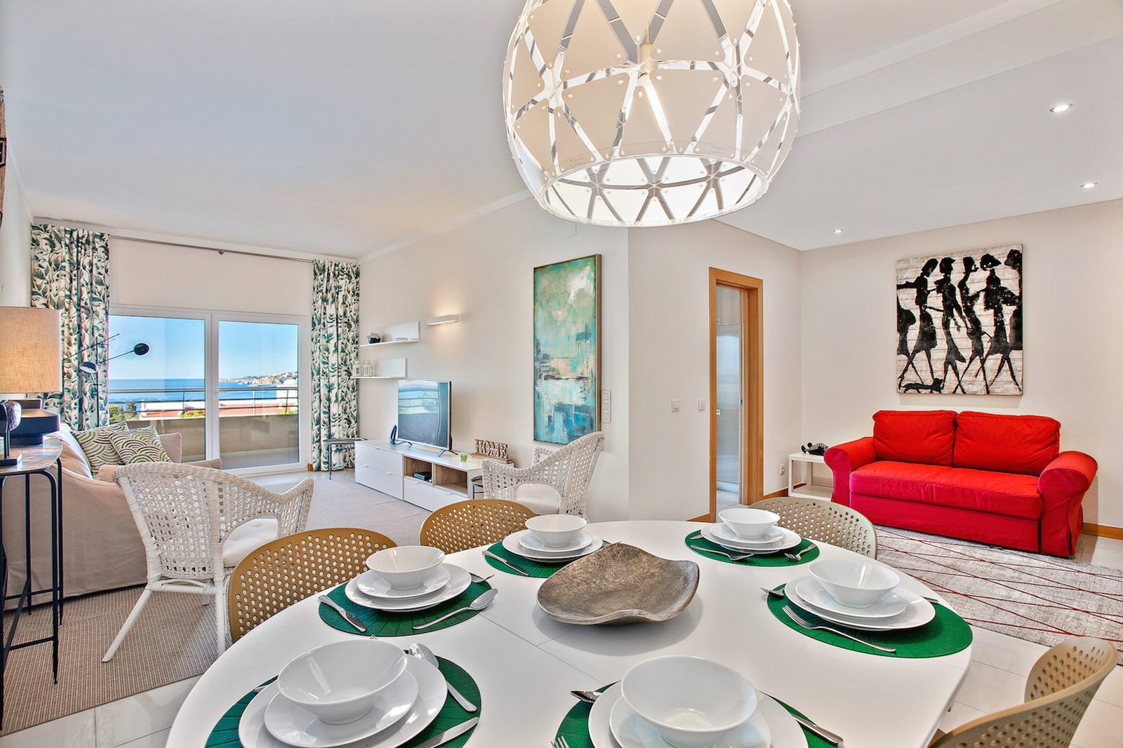 Living and dining area with sofa, dining table, and sea view