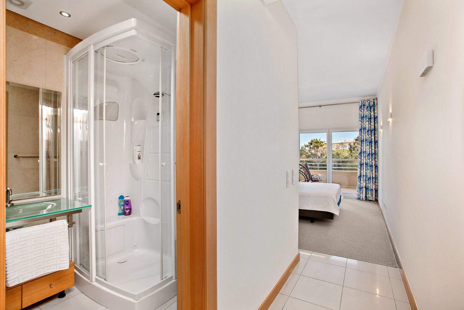 Shower room with corner cubicle and view through to the bedroom
