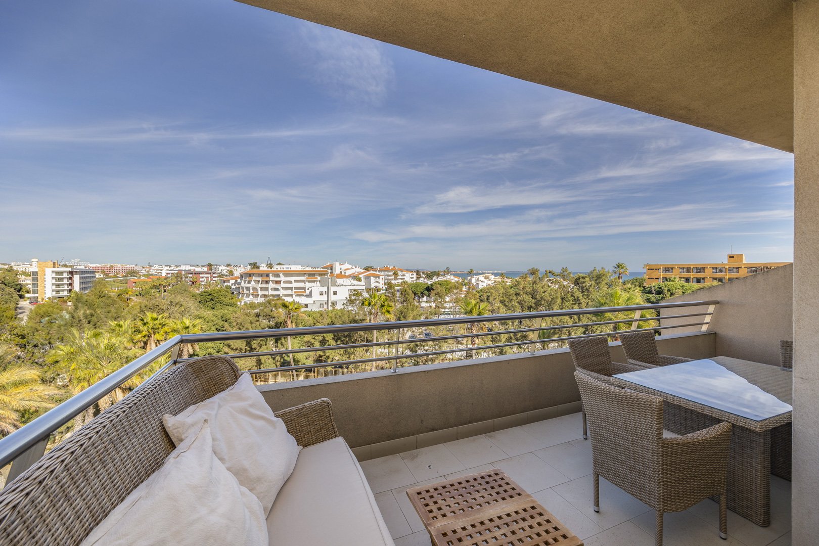 Balcony with wicker sofa, dining table, and town view