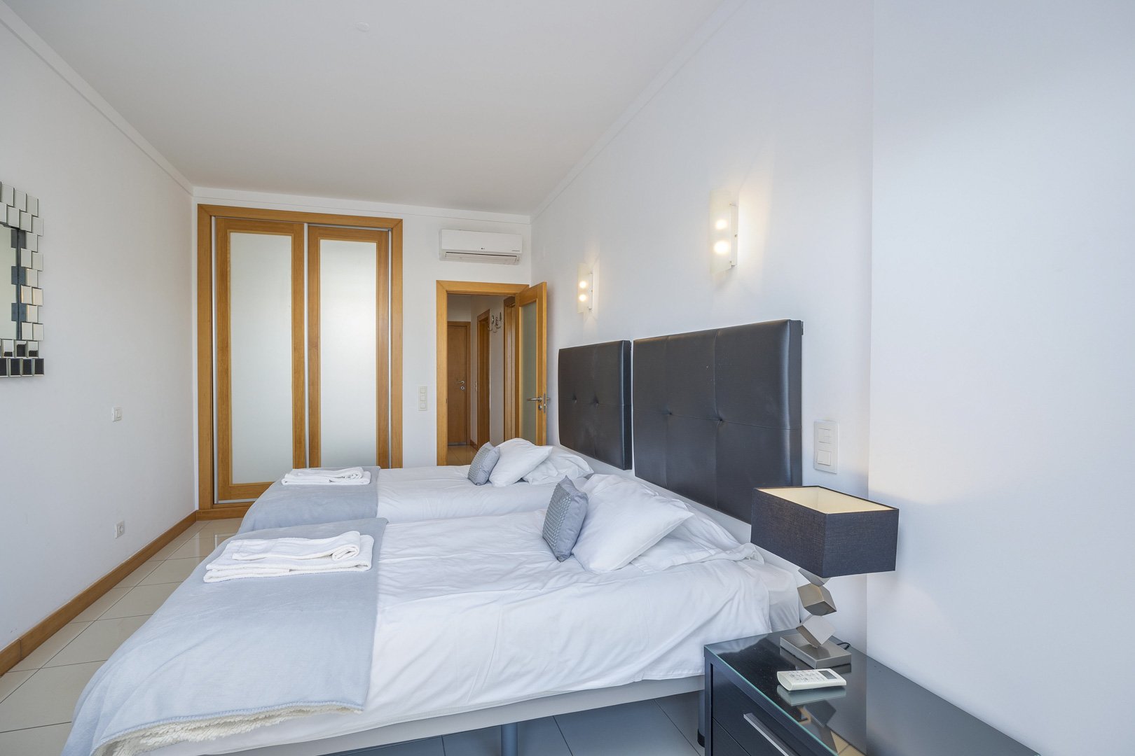 Bedroom with beds pushed together and access to the balcony and hallway