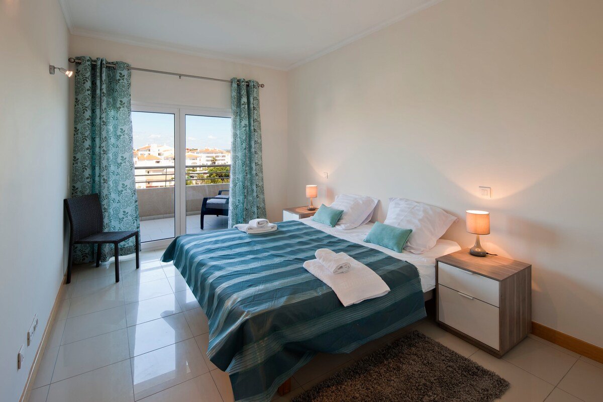 Bedroom with teal decor and balcony access