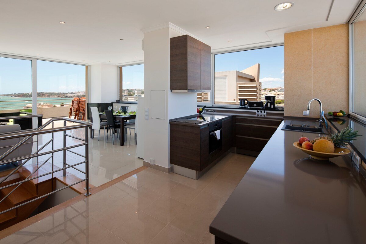Kitchen with dark wood cabinetry and panoramic sea and city views