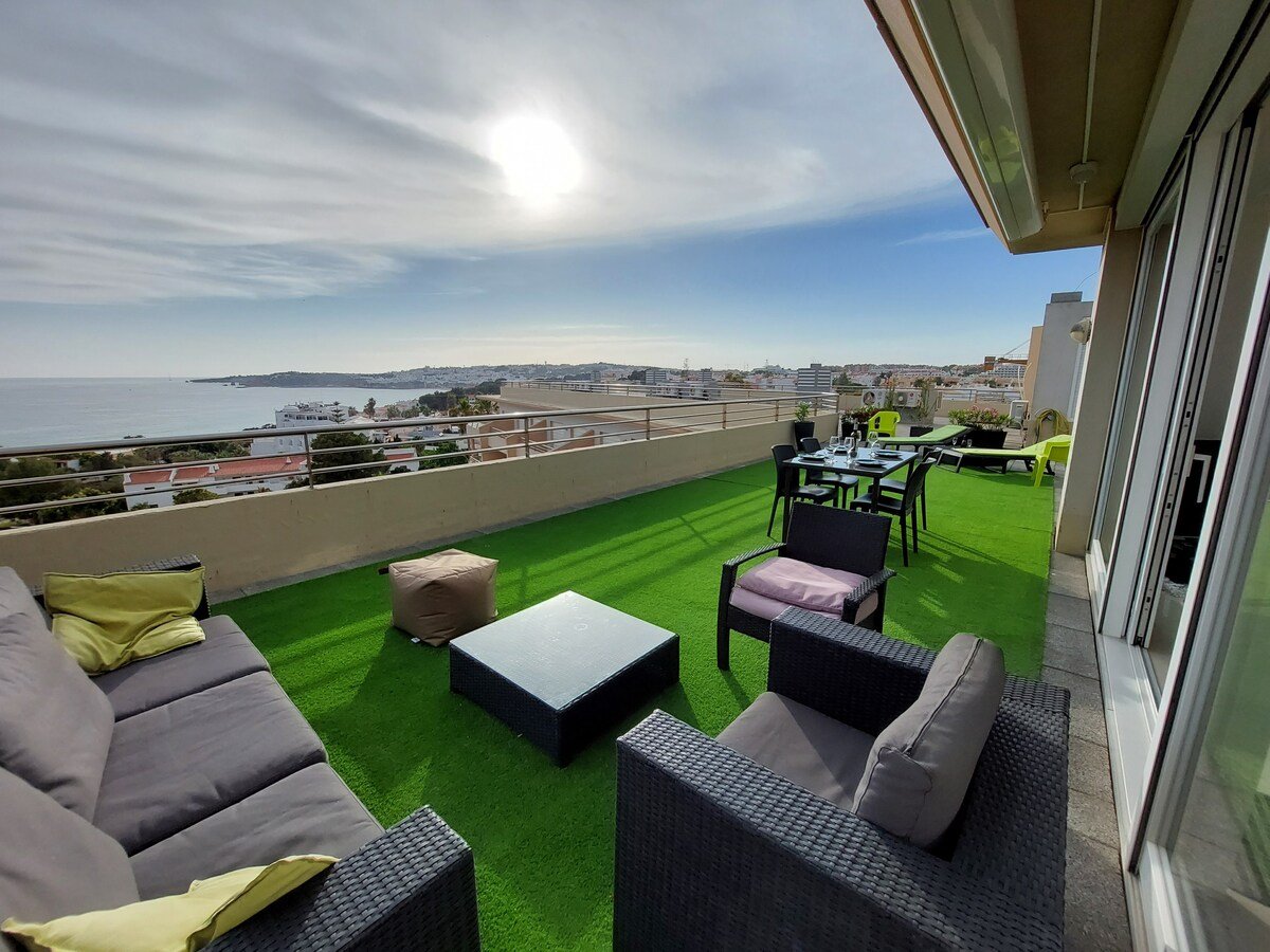 Private terrace with artificial lawn, dining table, and sofa seating