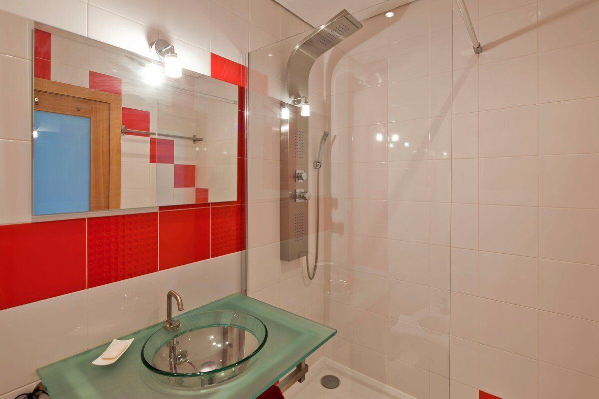 Shower room with red mosaic tiling and glass screen