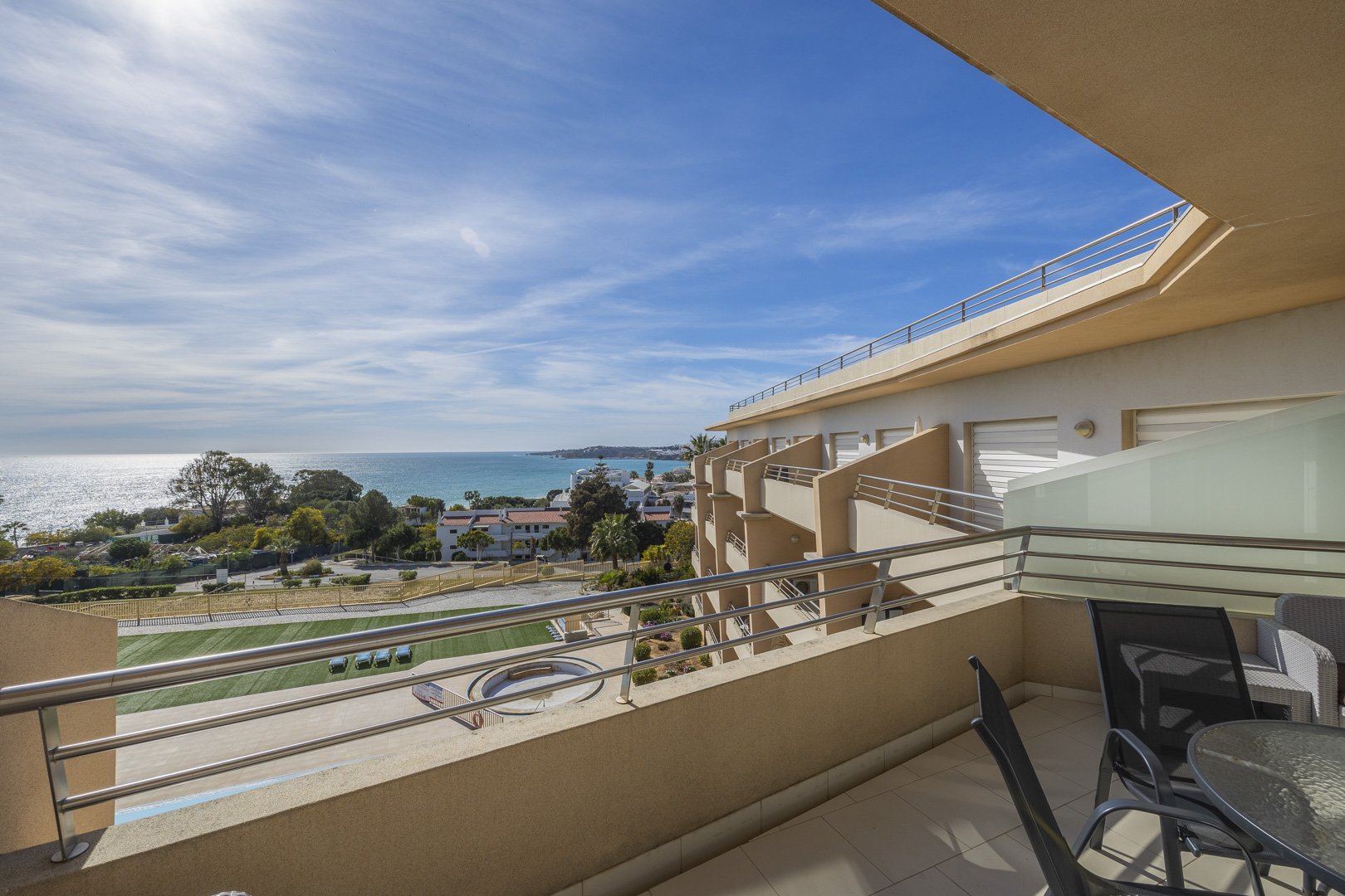 Balcony with dining table, chairs, and pool and sea view