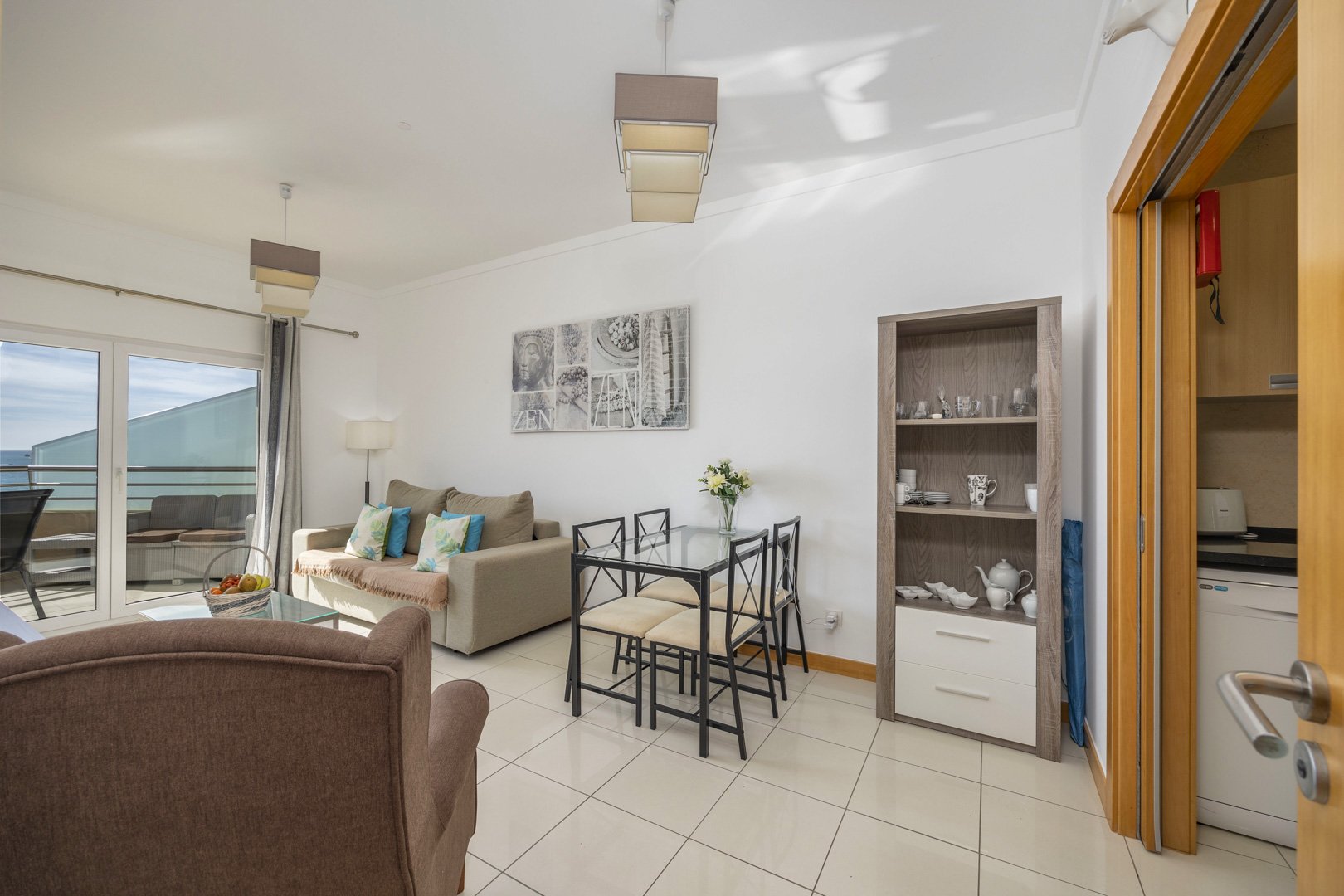 Living and dining area with armchair, dining table, and view through to the kitchen