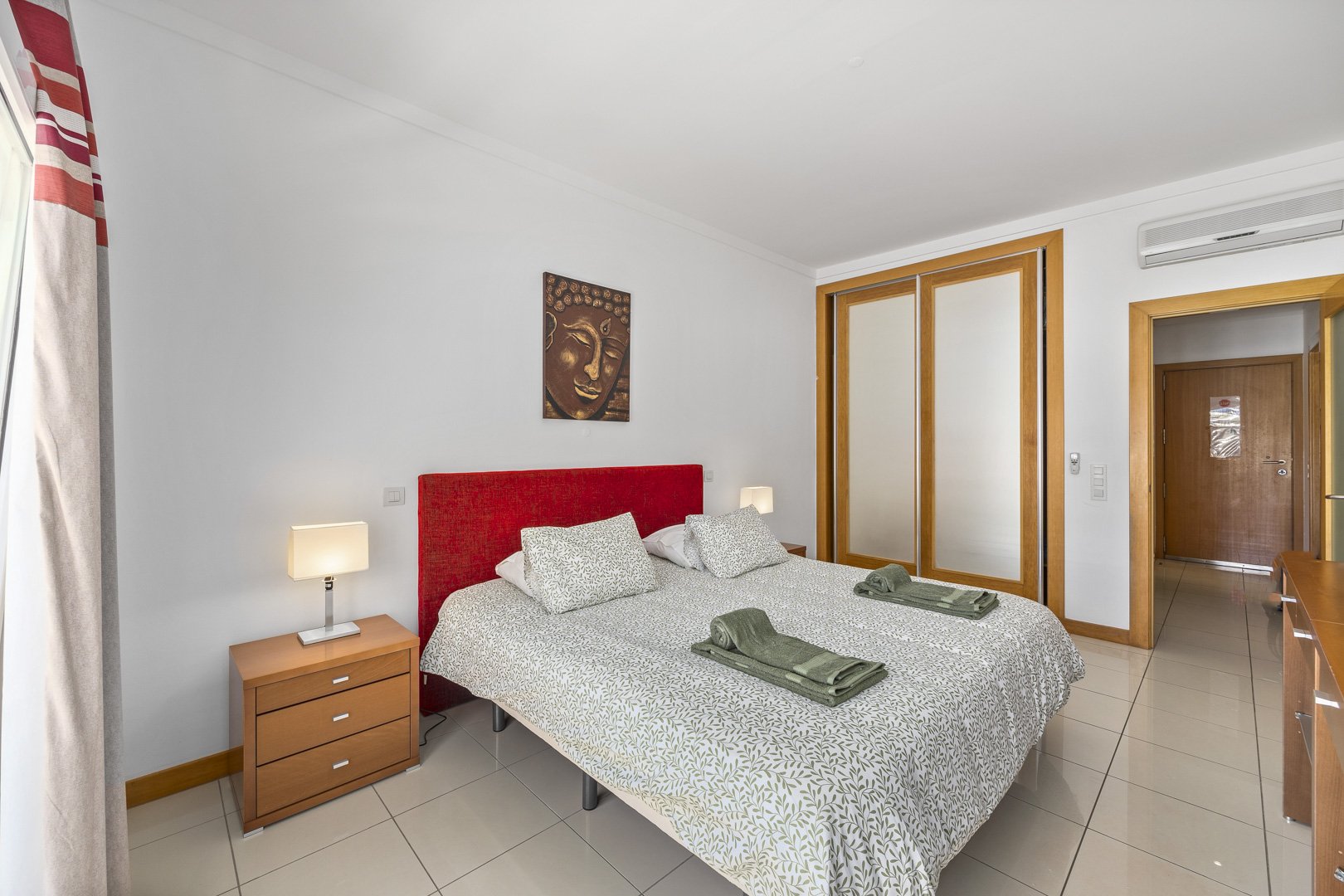 Bedroom with mirrored wardrobe doors and view through to the hallway