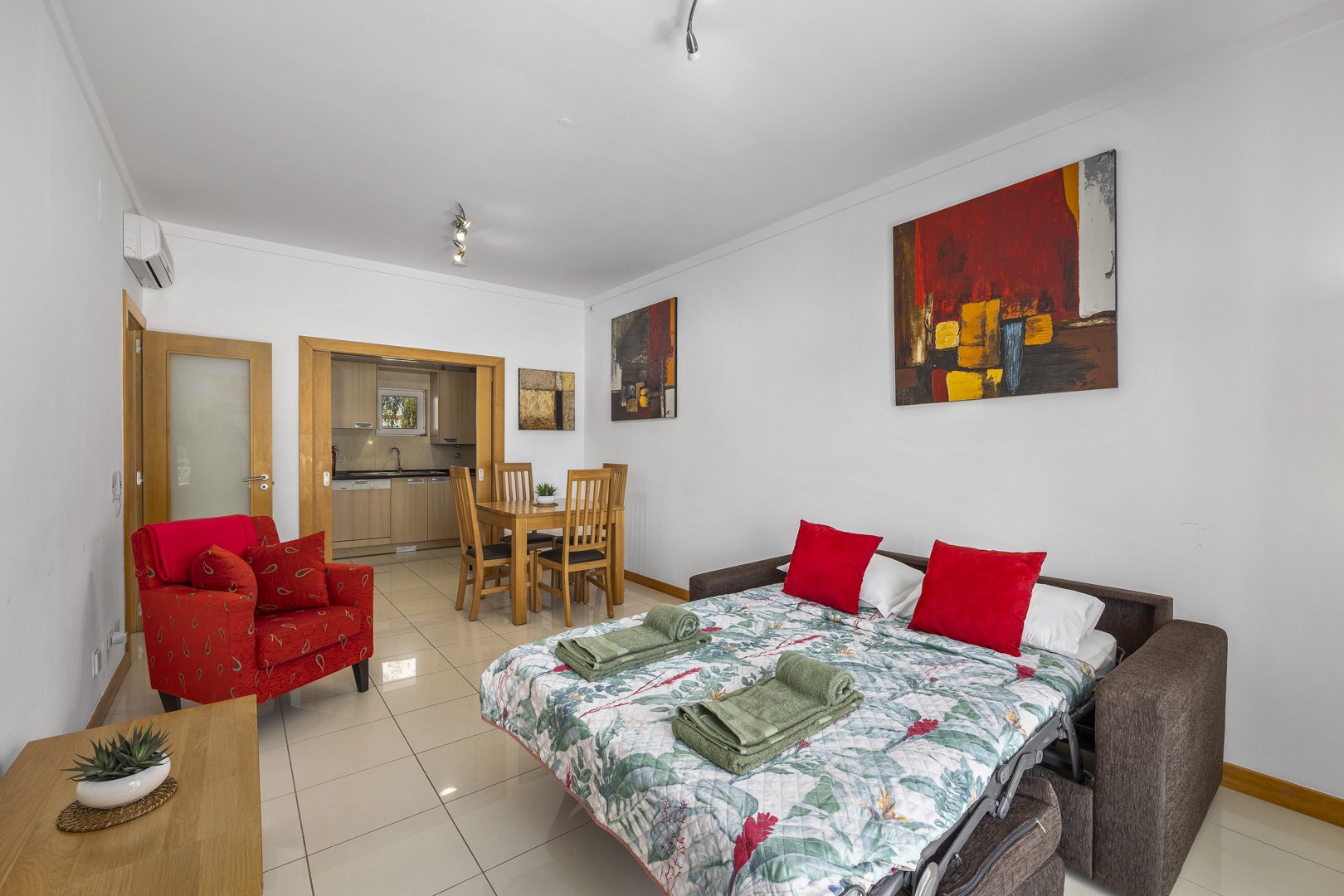 Living area with sofa bed, armchair, and kitchen access