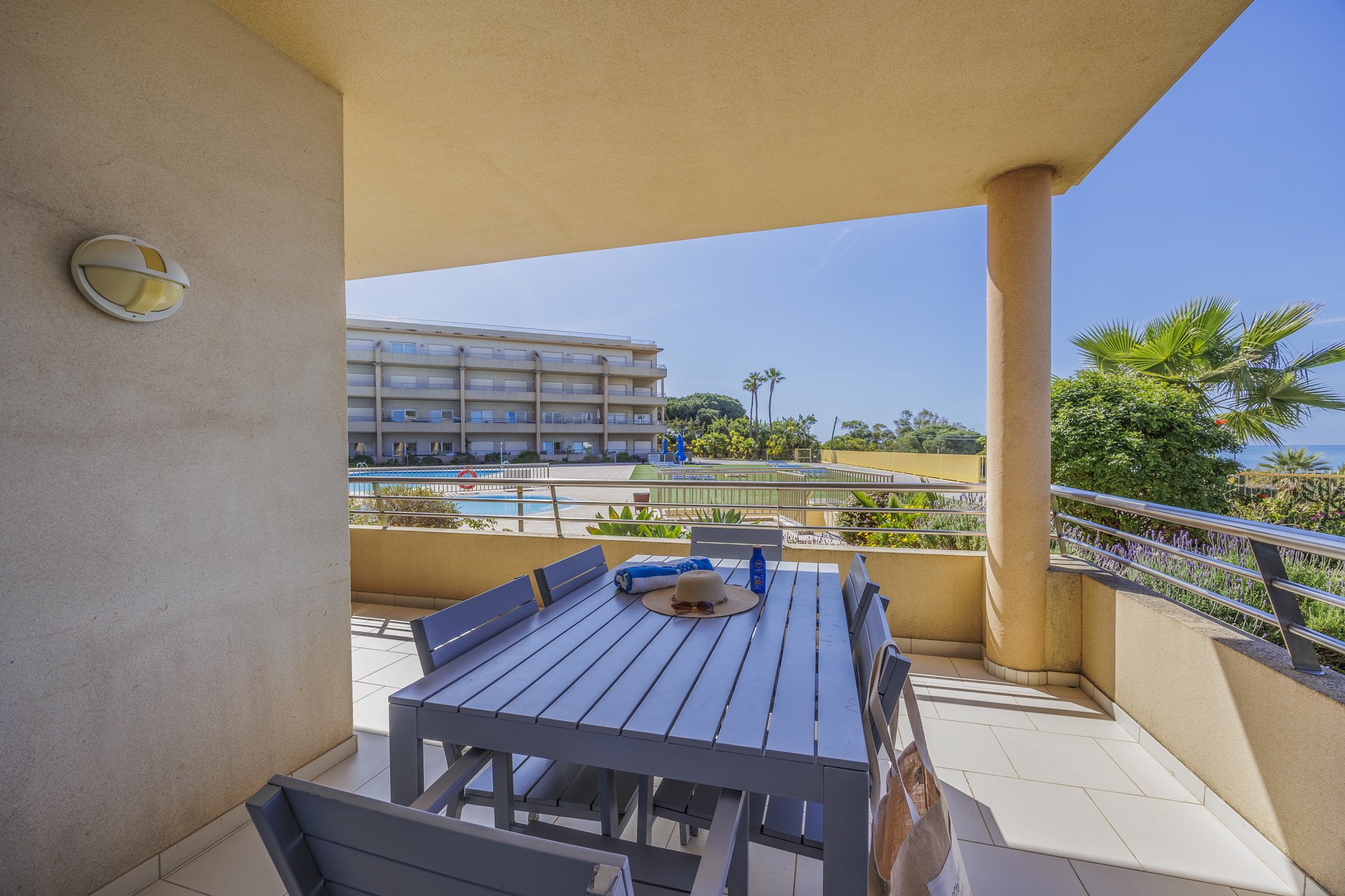 Balcony dining table with view over the pool and building