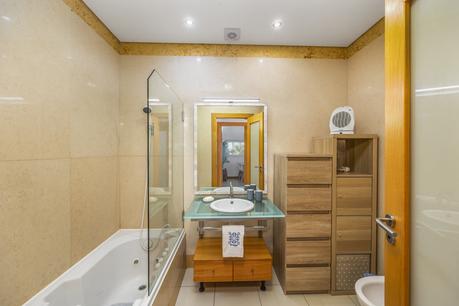 Bathroom with bathtub, glass shower screen, and vanity sink