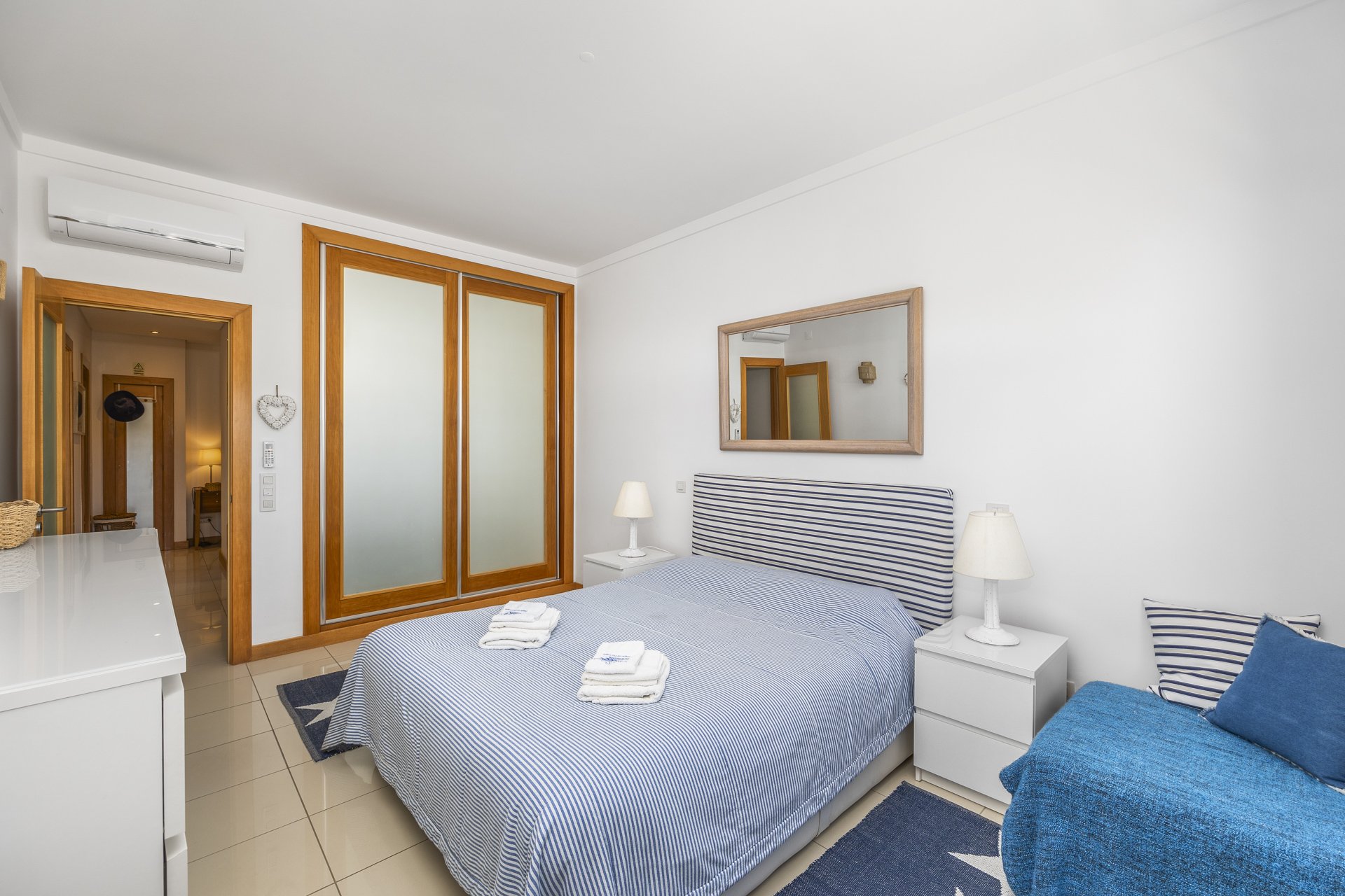 Bedroom with mirrored wardrobe and view through to the hallway