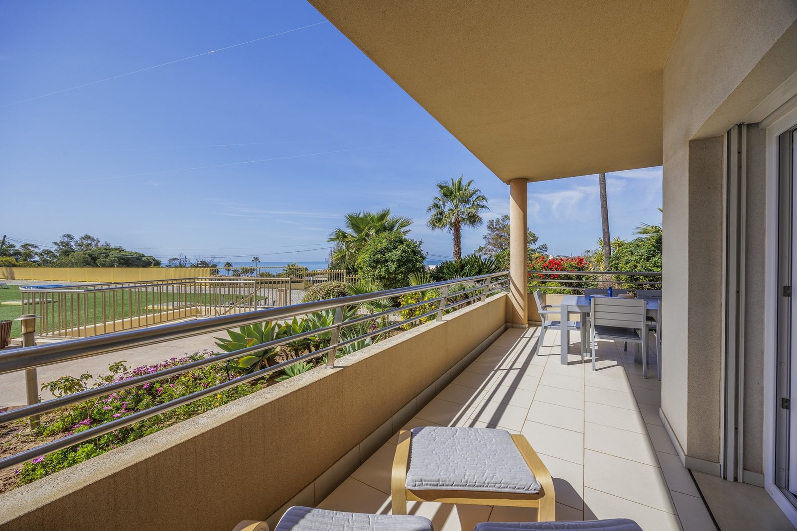 Balcony dining area with table, chairs, and sea view
