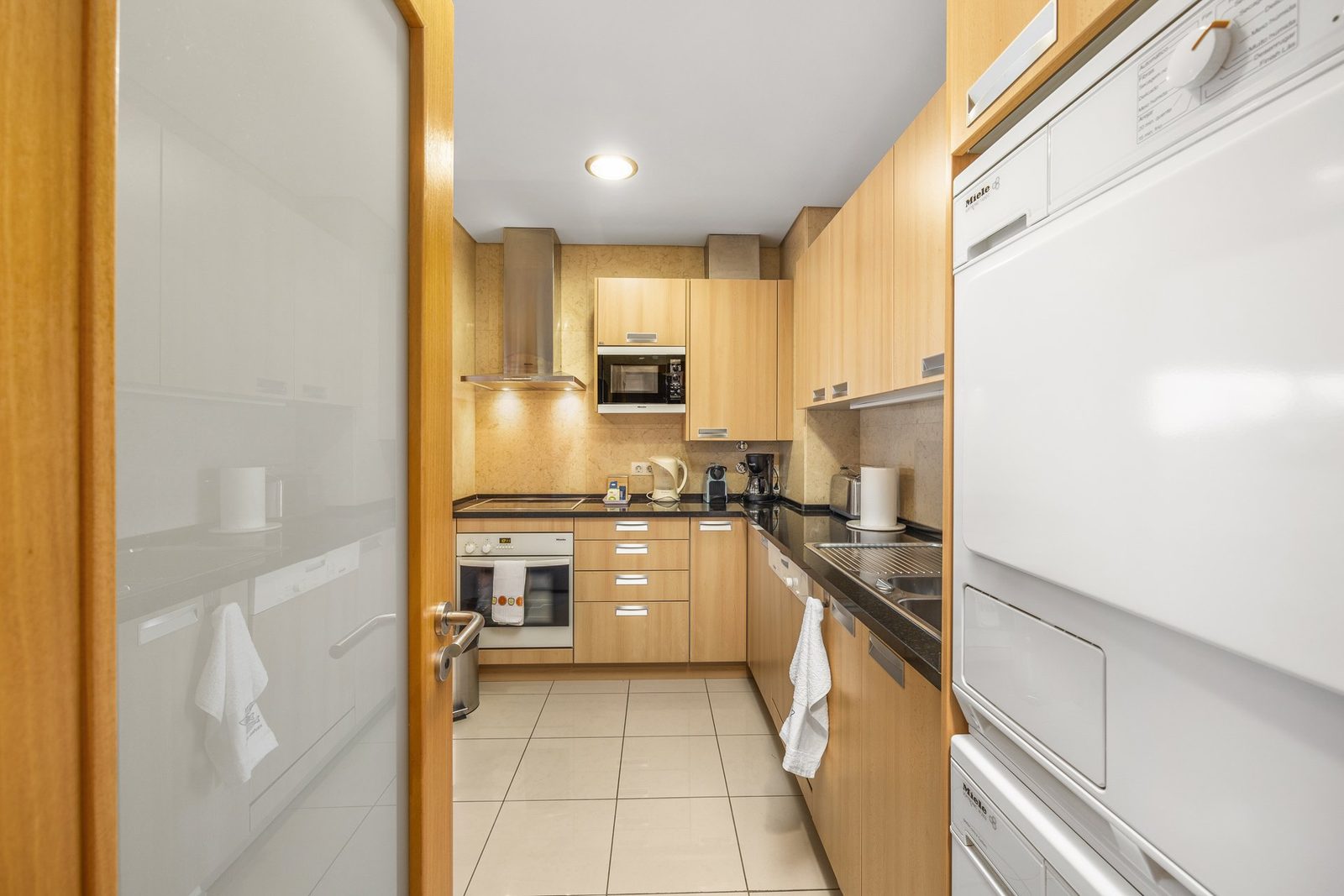 Kitchen with wooden cabinetry and integrated appliances
