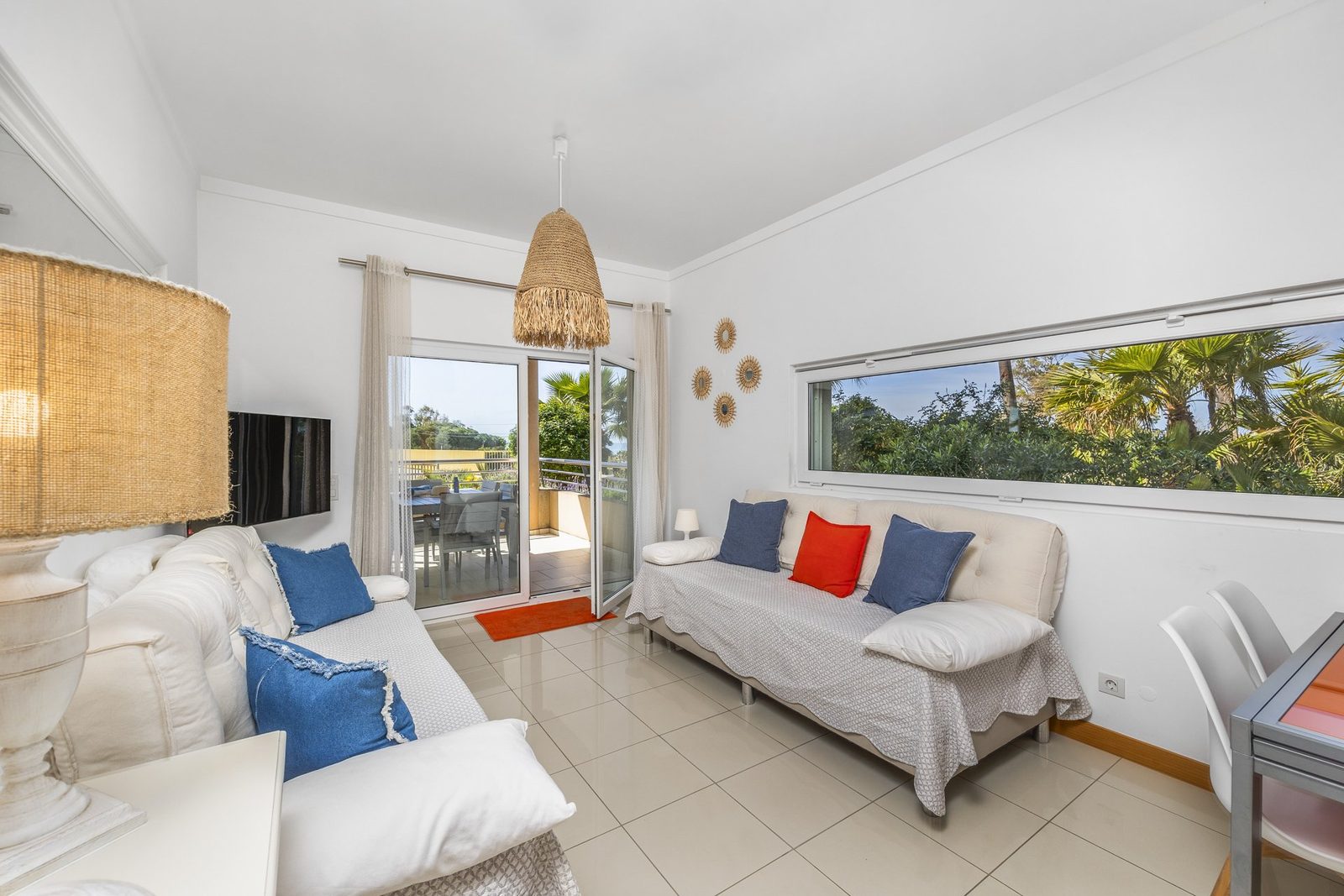 Living room with sofas, TV, and balcony access