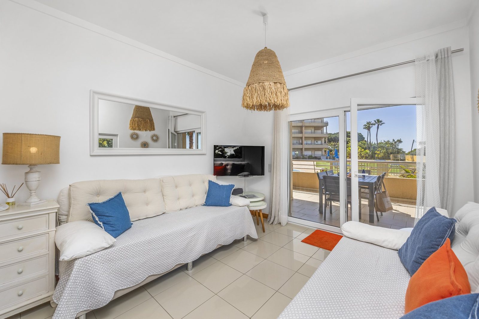 Living room with sofas and a glimpse of the sea through the balcony